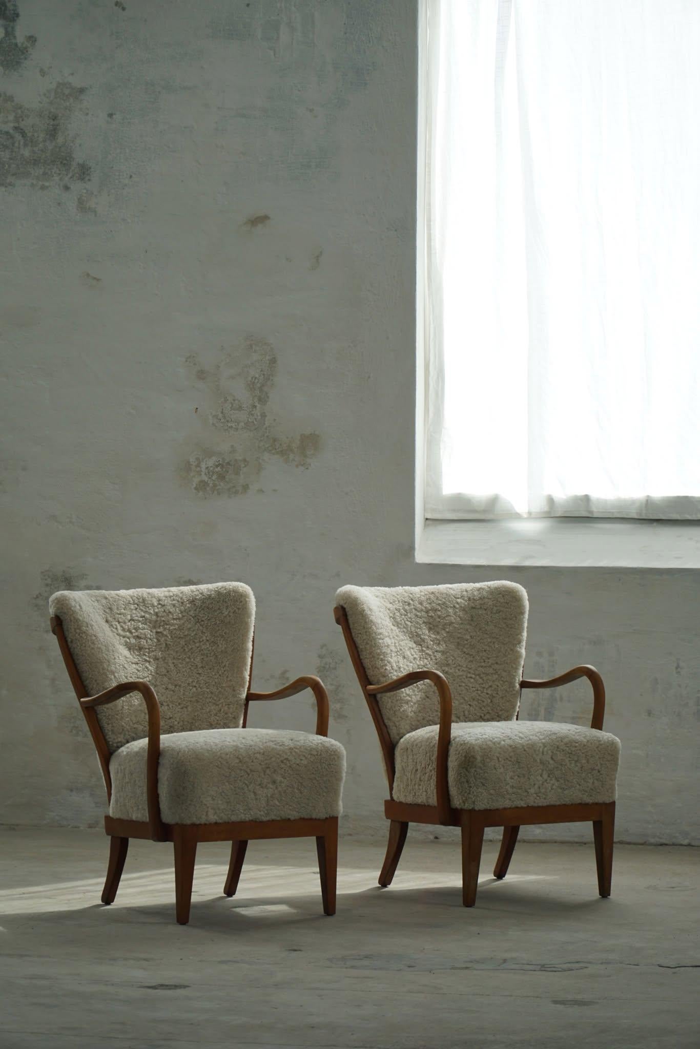 This pair of easy chairs, crafted by Alfred Christensen for Slagelse Møbelfabrik in the 1940s, epitomizes Danish modern design. Constructed from beech, these chairs feature a sturdy yet elegant frame. The seat and back cushions have been