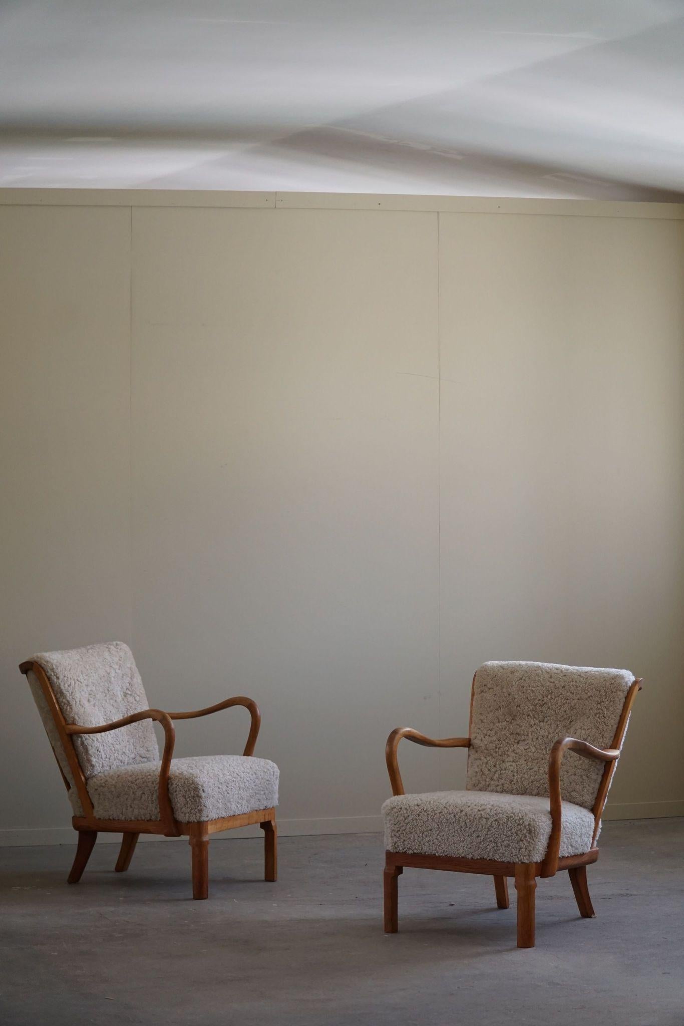 This rare pair of easy chairs, crafted by Alfred Christensen for Slagelse Møbelfabrik in the 1940s, epitomizes Danish modern design. Constructed from oak, these chairs feature a sturdy yet elegant frame. The seat and back cushions have been
