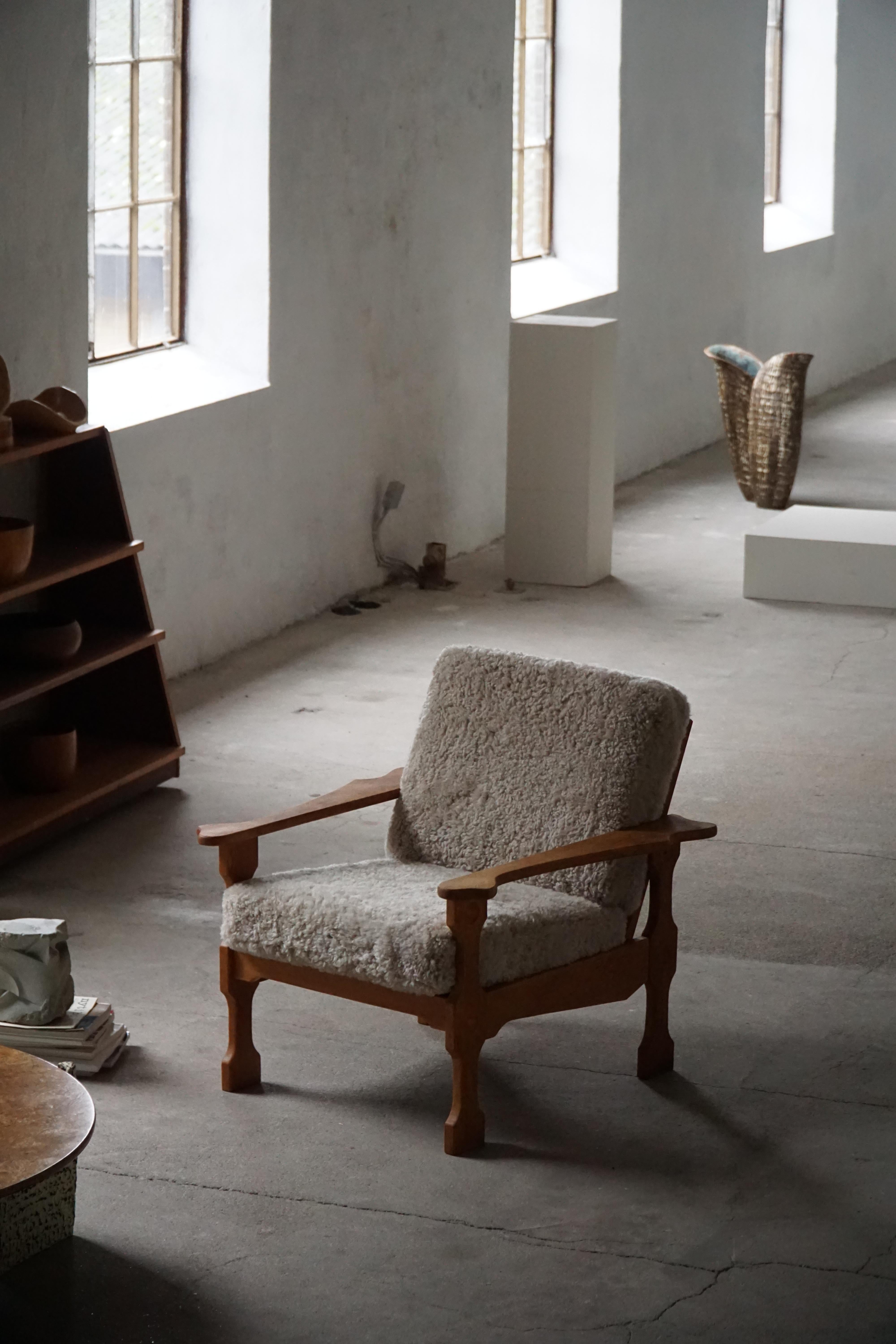 Ein beeindruckendes Paar moderner dänischer Loungesessel im Stil von Henning (Henry) Kjærnulf. Hergestellt aus Eichenholz und neu gepolsterten Kissen aus hochwertiger Lammwolle in hellem Off-White. Hergestellt in den 1960er Jahren von einem