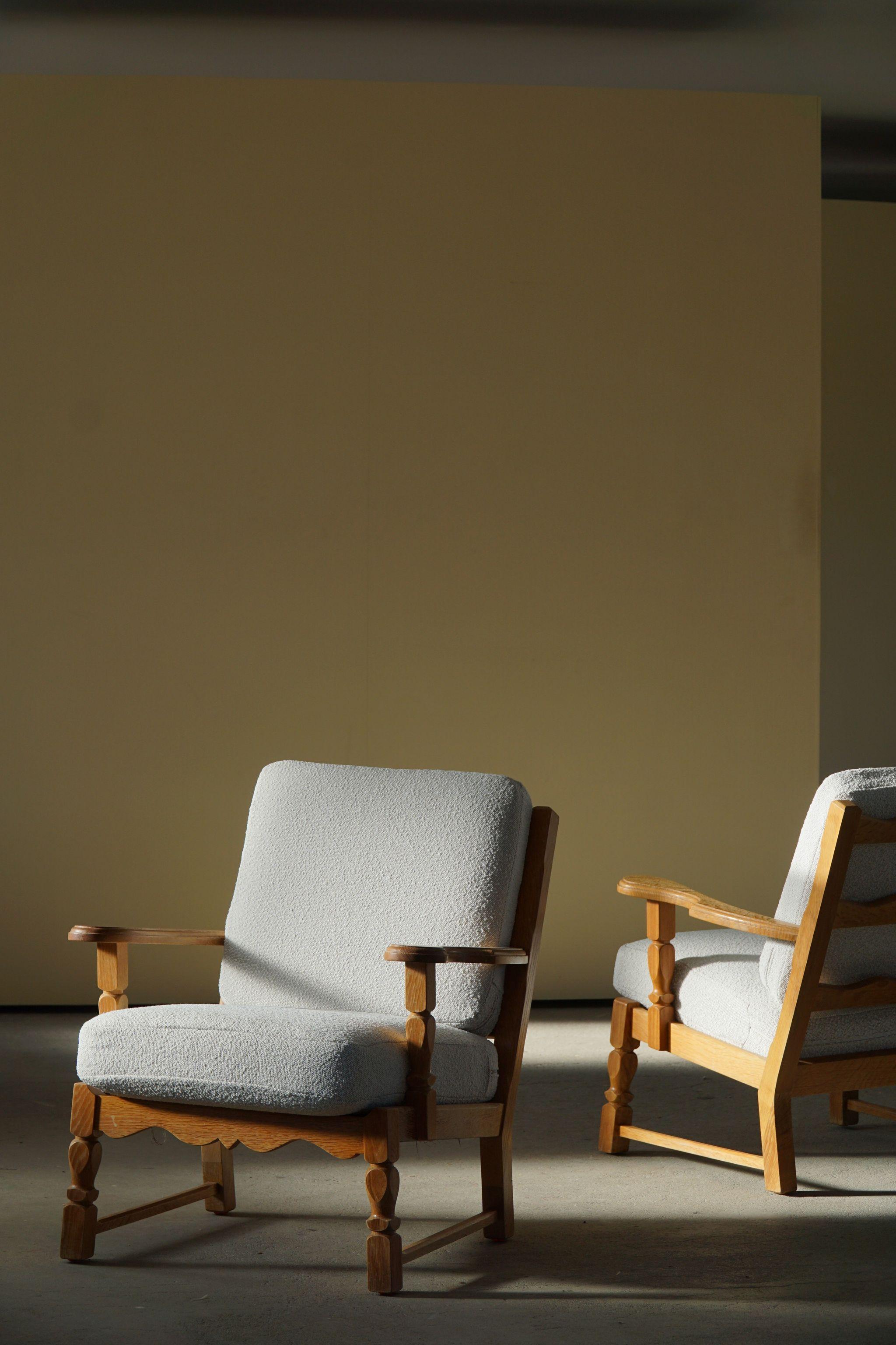 A pair of mid-century lounge chairs in style of Henning Kjærnulf. Made in oak and reupholstered in bouclé. Made in 1960s by a Danish Cabinetmaker.

These nice vintage chairs fits in many interior styles. Modern, Scandivinavian interior, Art Deco