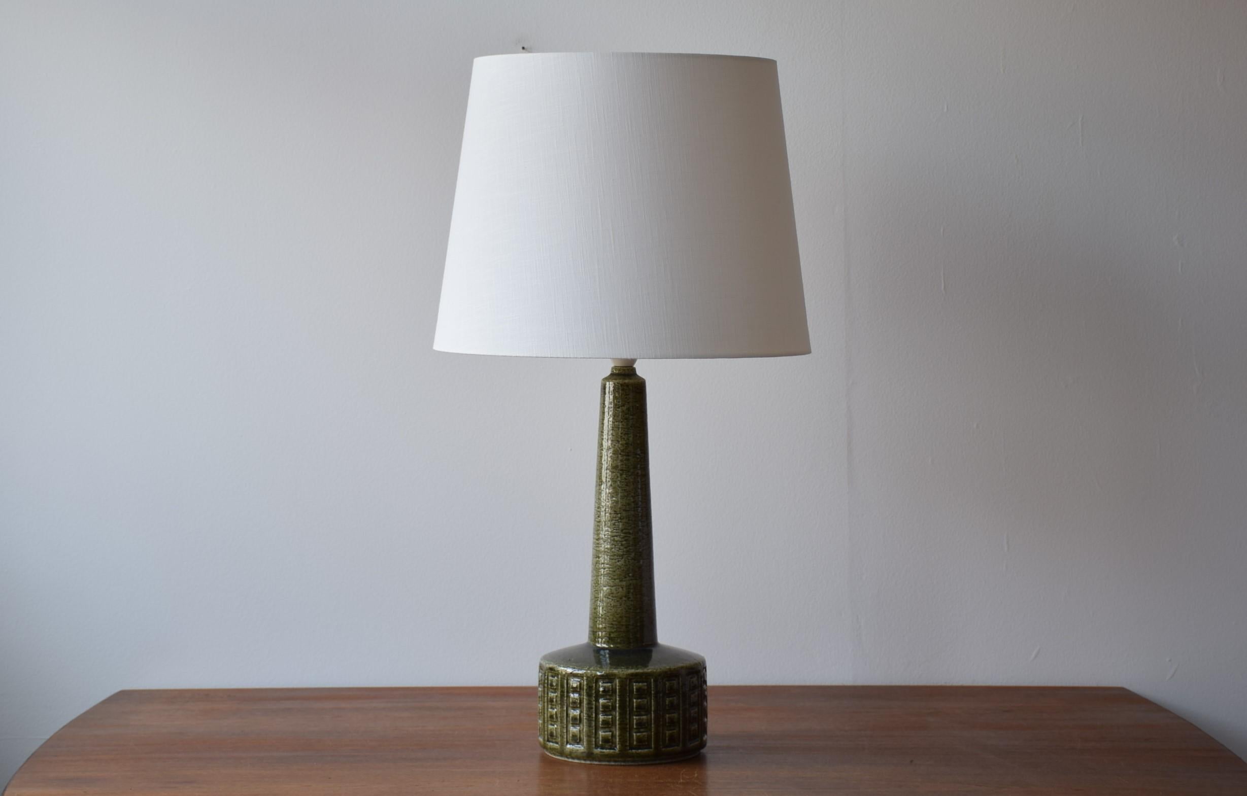 Midcentury tall table lamp from Danish Palshus.
The lamp was designed by Per Linnemann-Schmidt and produced, circa 1960s.
It is made with chamotte clay which gives a rough and vivid surface. The glaze is moss green with a little blue on