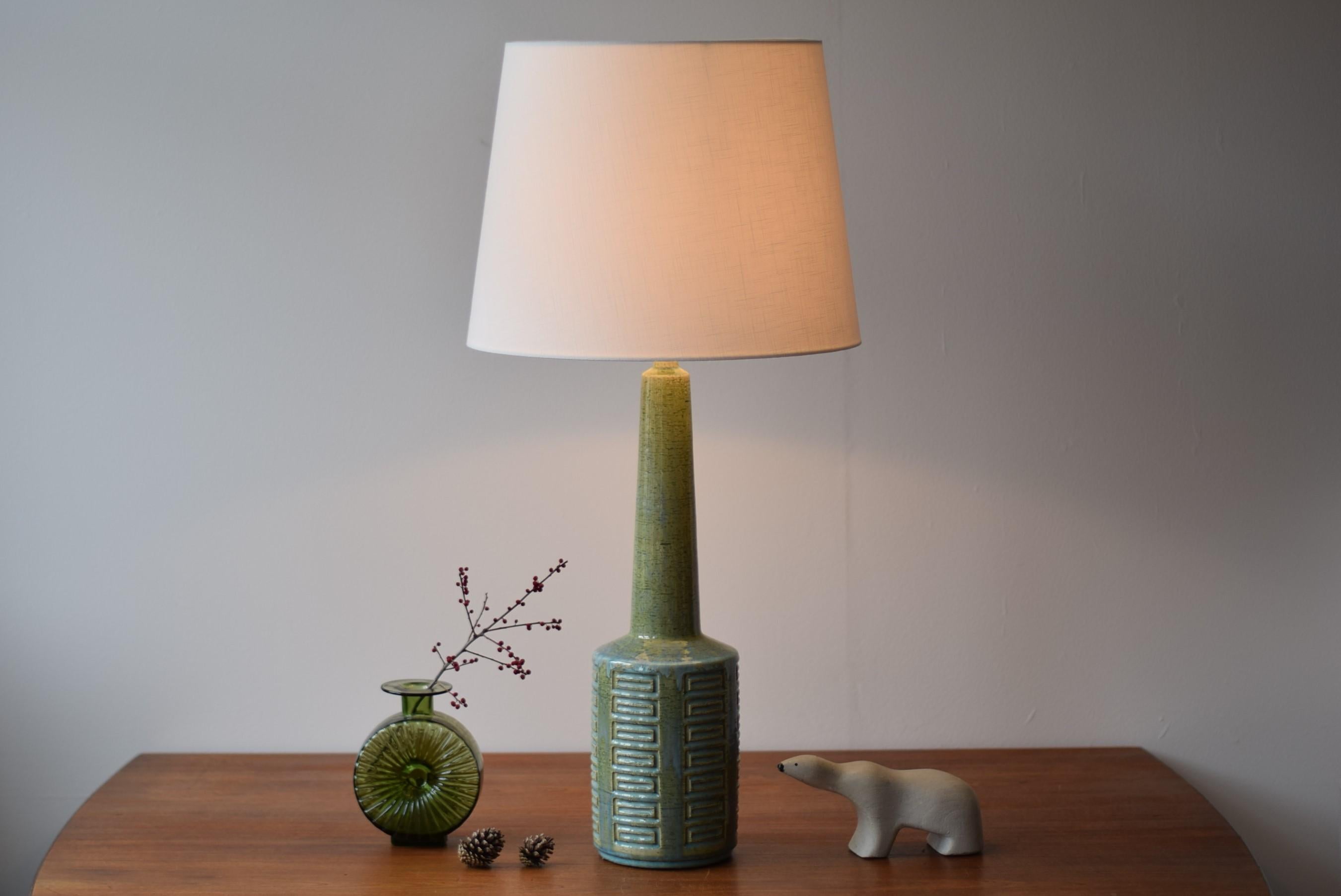 Midcentury tall table lamp from Danish Palshus.
The lamp was designed by Per Linnemann-Schmidt and produced, circa 1960s or early 1970s.
It is made with chamotte clay which gives a rough and vivid surface. The glaze is grass green glaze with pale