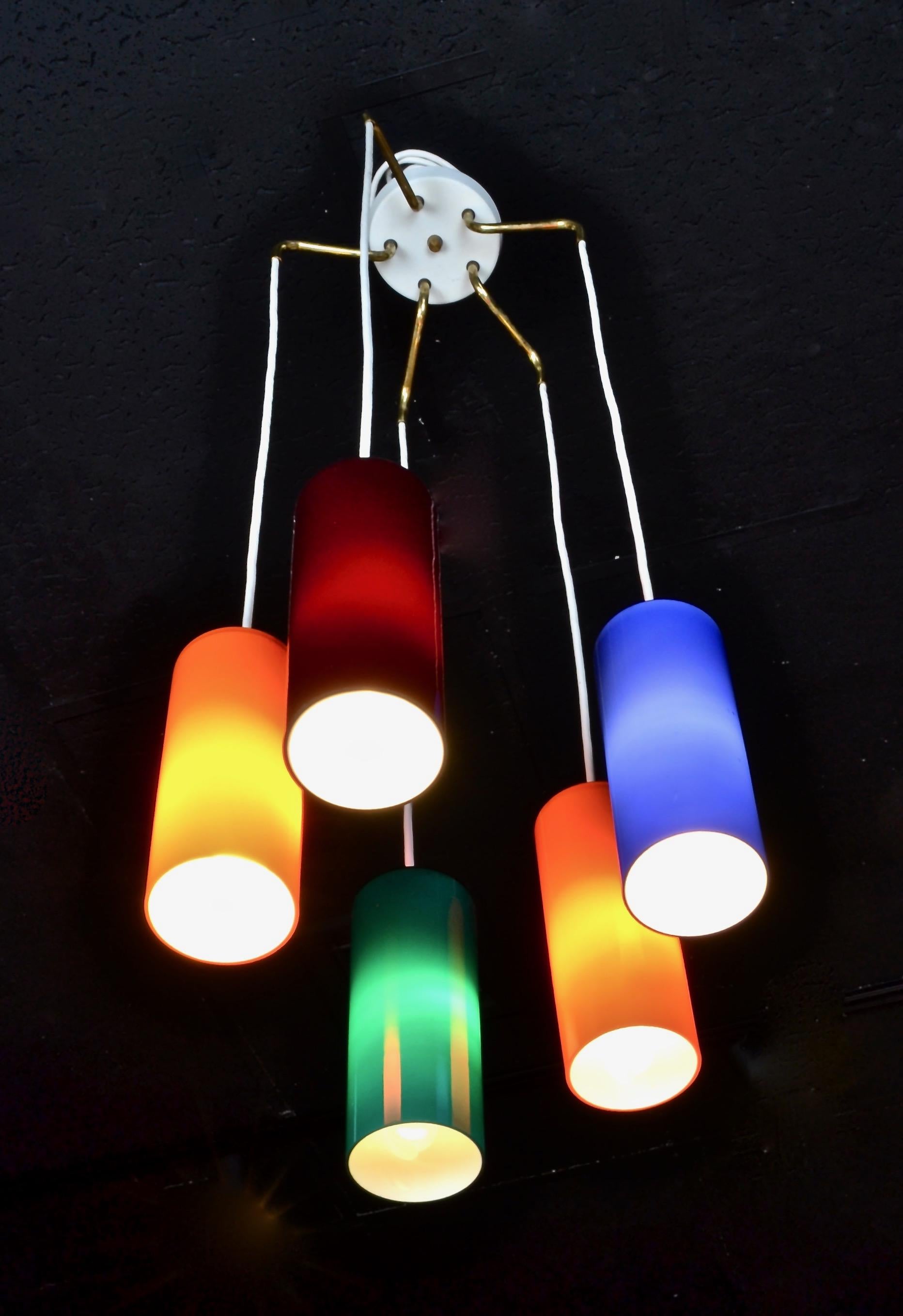 Five cylindrical vibrantly colored case glass pendants suspended from a center ceiling fixture. Shown at level lengths but extra wire provided so that pendants may be staggered if desired. Also, total length is adjustable. All updated wiring. Each