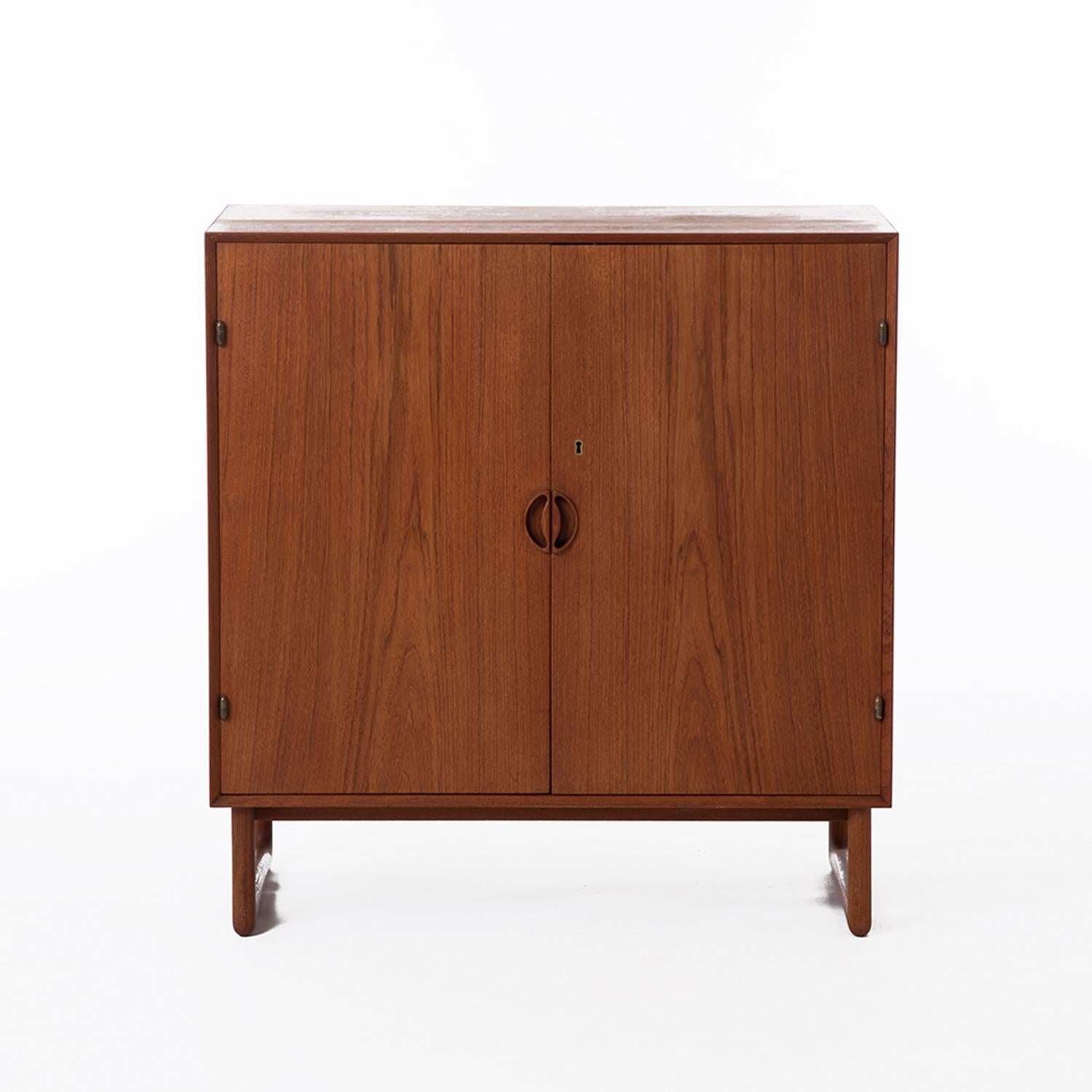 A Peter Hvidt and Orla Molgaard designed occasional cabinet. Solid teak construction with beautiful exposed joinery along the top and bottom of the case. Unusual sled base option. Interior adjustable shelving with locking door. 



Professional,