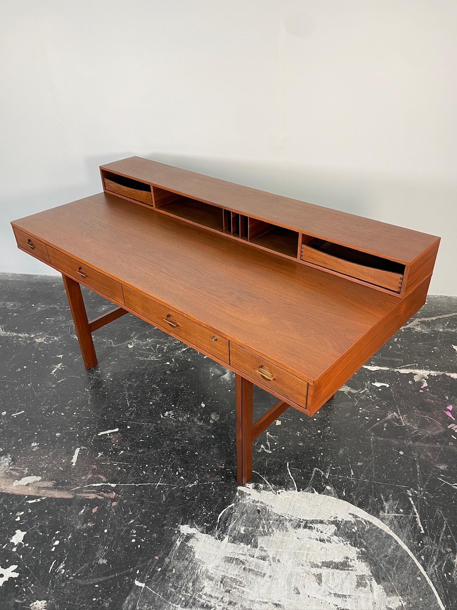This flip-top partner desk by Peter Løvig Nielsen for Dansk in Denmark has been immaculately restored. It has a gorgeous deep hue, old-growth quarter-sawn teak with beautiful flecks in the wood. Quarter-sawn teak is incredibly strong and means this