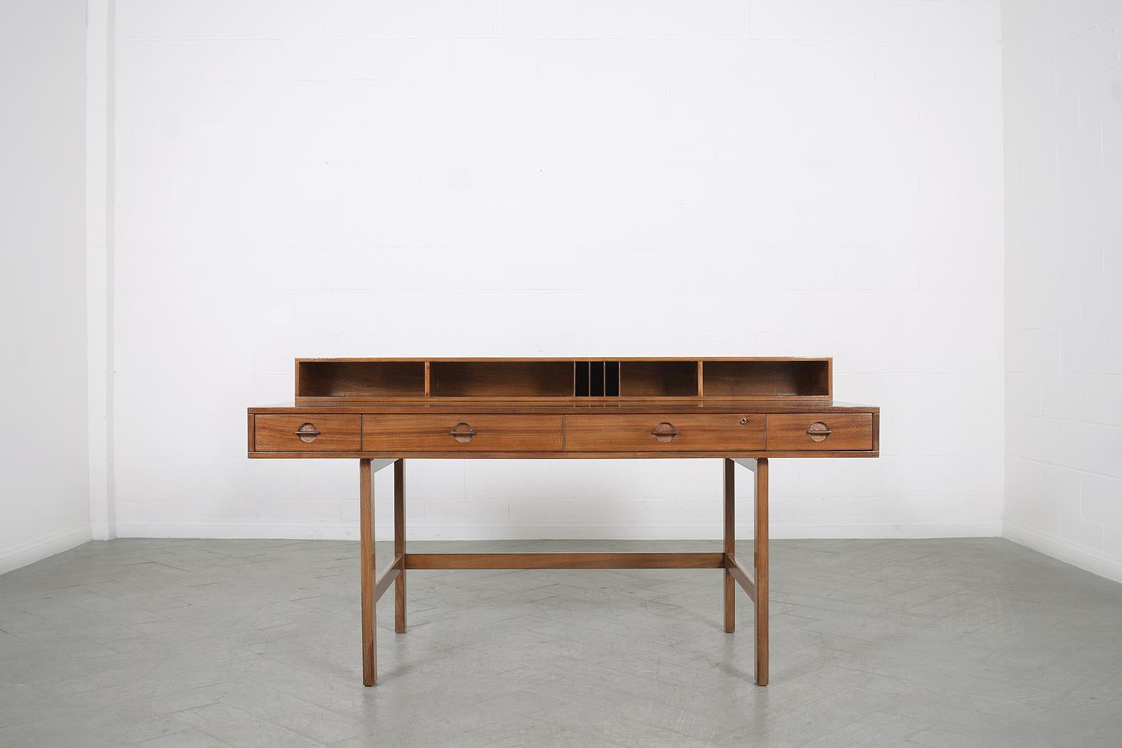 This extraordinary danish modern teak desk was designed and crafted by the iconic Peter Løvig Nielsen in Denmark circa the 1970s. Its ingenious design makes it versatile in accommodating two persons on each side by simply flipping the top shelf and
