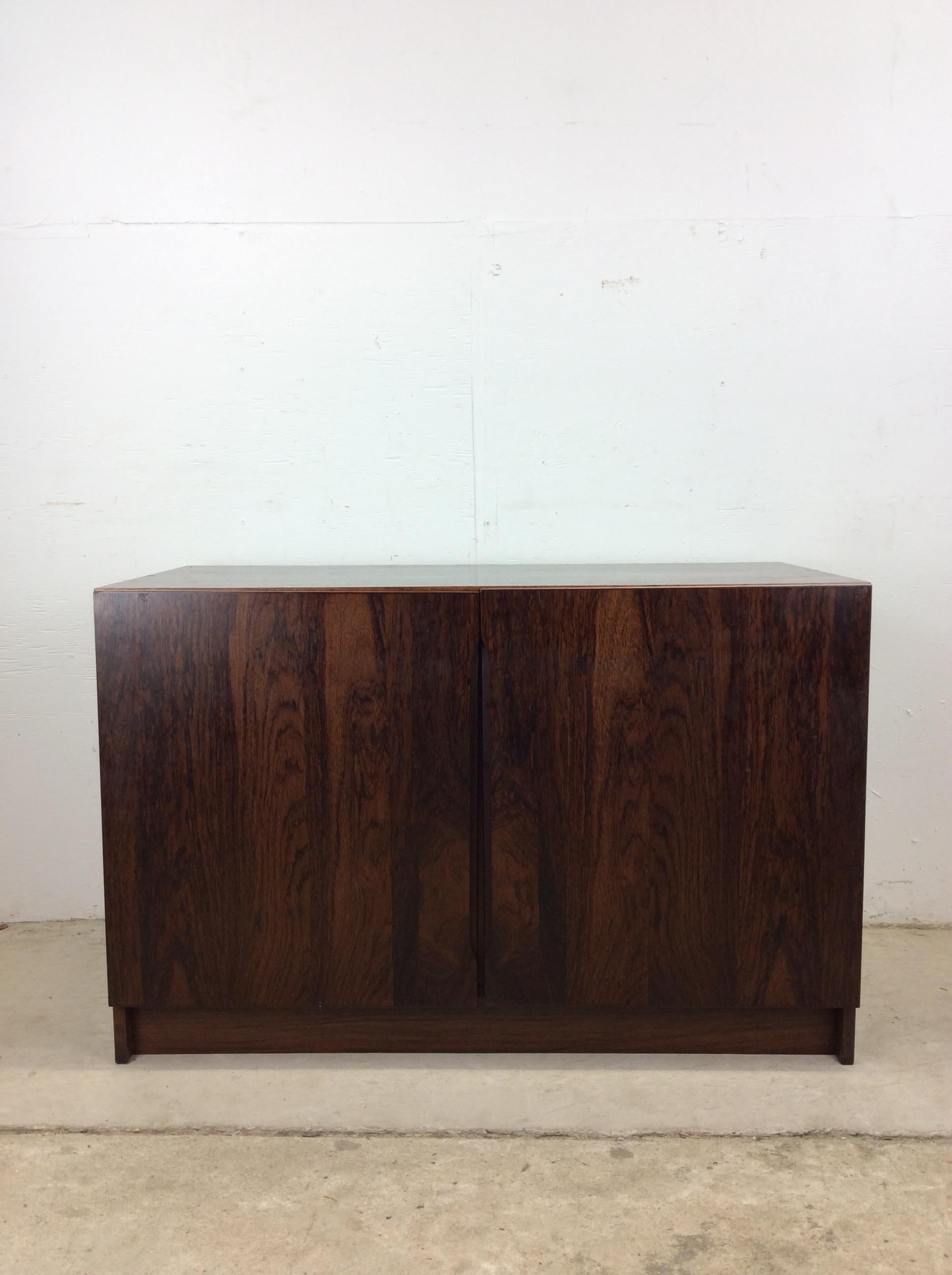 Questa credenza danese moderna di piccole dimensioni presenta una struttura in legno massiccio, una splendida impiallacciatura in palissandro con finitura originale e due ante contenenti tre ripiani regolabili.

Dimensioni: 39,5 l 19,25 p 25,5
