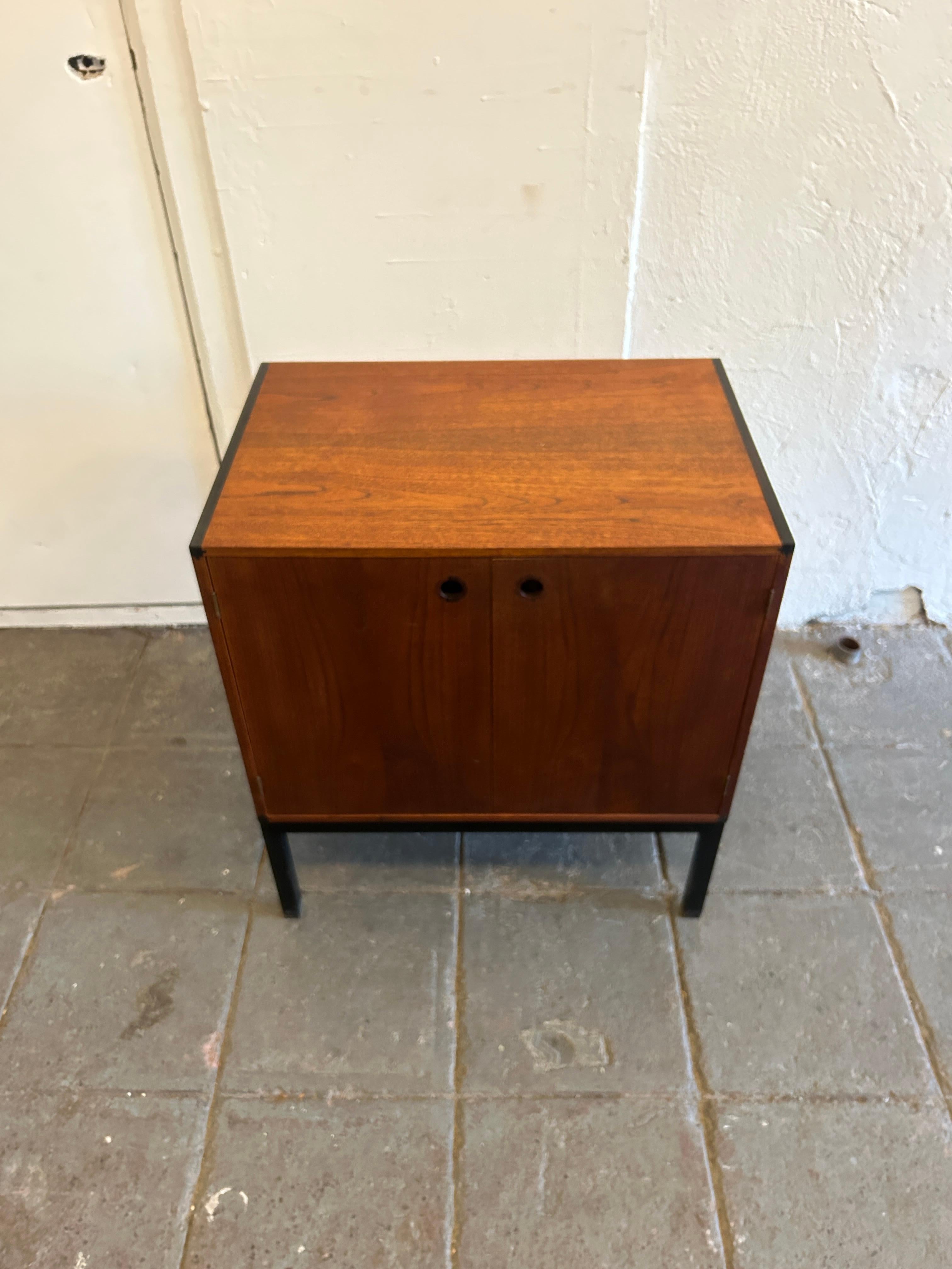 Scandinavian modern teak petite cabinet by Hans Hove & Palle Petersen by Christian Linneberg mobler. Teak construction with rosewood corners and small hole pulls with a black steel square tube frame and brass hinges. Good vintage condition. Has (1)