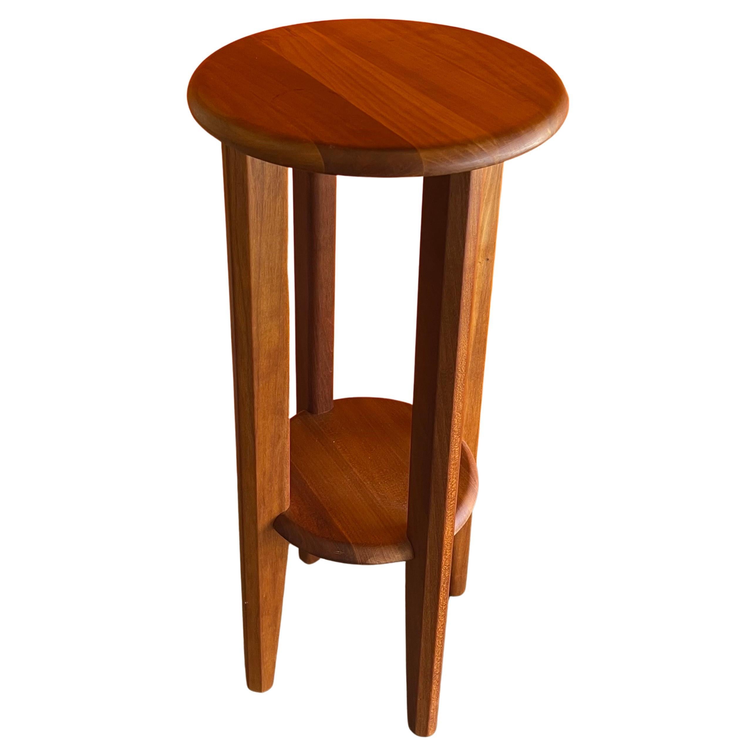 Danish modern petite teak side table / plant stand by Ansbarger Møbler, circa 1970s. This small table has beautiful wood grain with excellent detailing and craftsmanship. The table is in very good vintage condition and measures 10