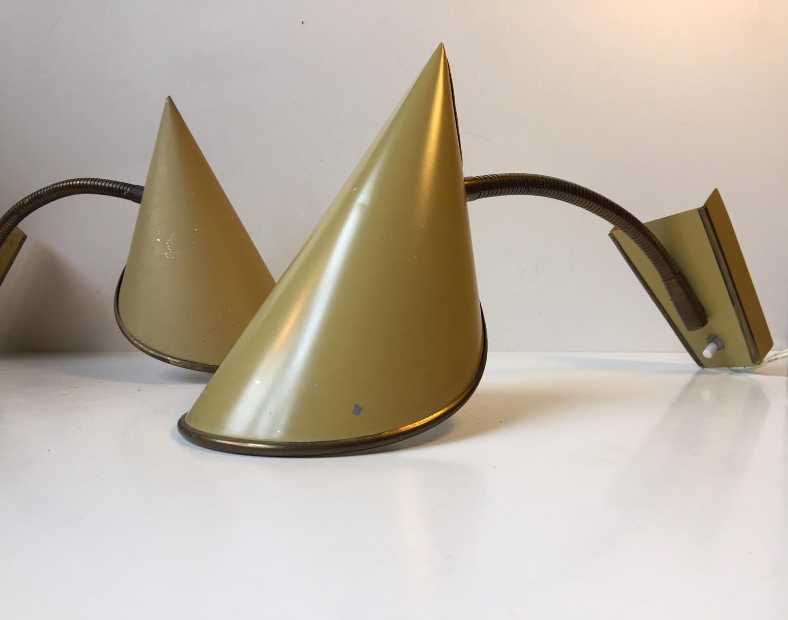 This pair of adjustable wall lights was manufactured and designed by Fog & Mørup in Denmark during the 1950s. The set features folded and pointy pastel yellow shades and a flexible fully adjustable brass goose-neck. The style of these lights was