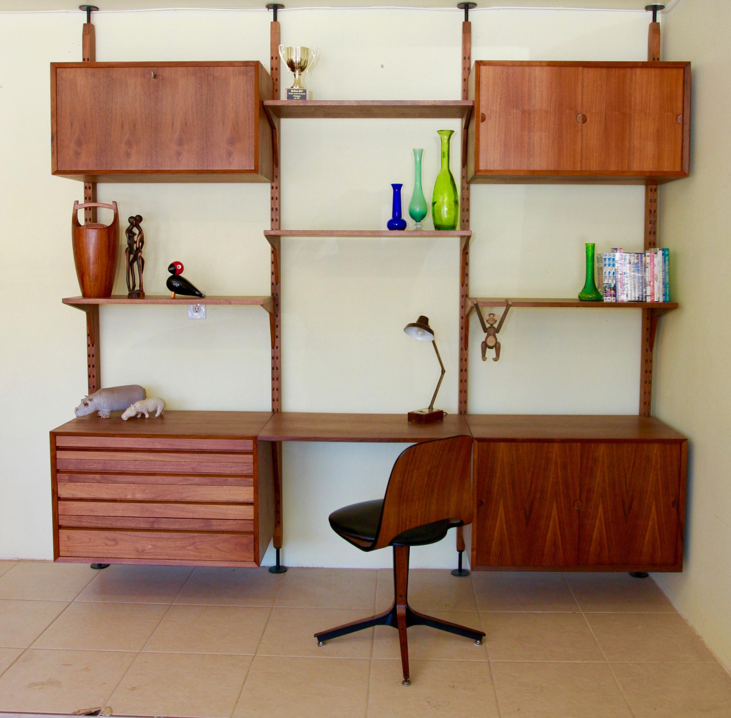 This royal wall unit system in Walnut, designed by Poul Cadovius was produced by Cado in Denmark. The modular system consists in 4 shelves, 4 cabinets with key and a desk and one large shelf that can be used also as a desk . The components can be