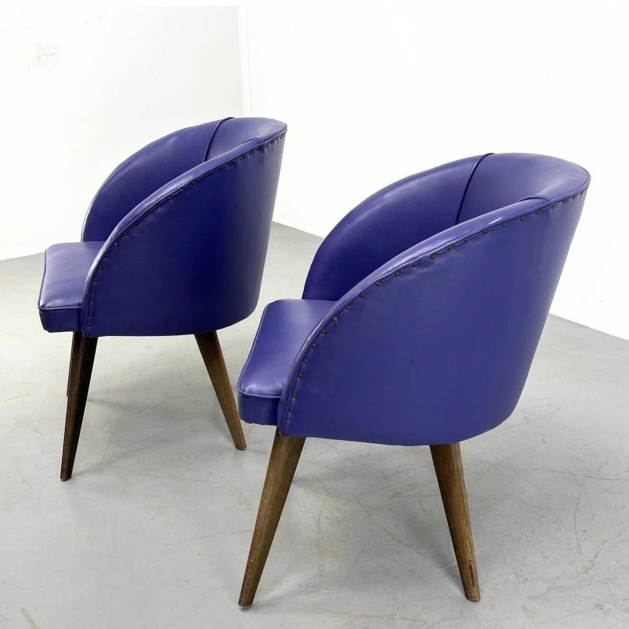 A fantastic pair of Danish Modern Purple Upholstered Barrel Tub Chairs.
Pair vintage vinyl purple barrel chairs. Studded around back. Tapered Angular legs. Dimensions: H: 29.5 inches: W: 25.5 inches: D: 22.5 inches - Seat Height: 17 inches -.