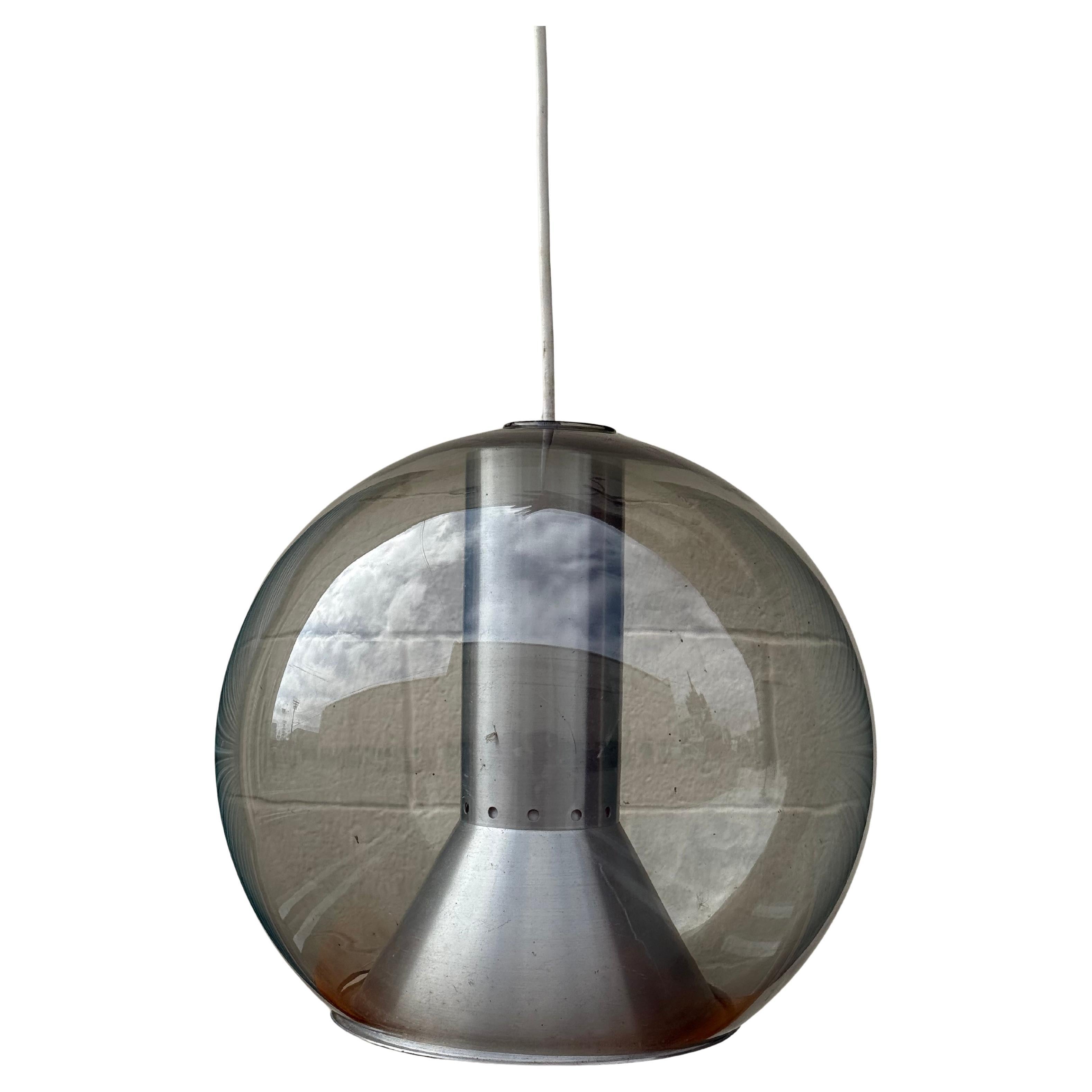 Iconic pendant light by Frank Ligtelijn for the Dutch lighting manufacturer RAAK Amsterdam, 1970s.

The globe is manufactured by the German glassworks Peill & Putzler and it contains a funnel-shaped aluminum interior.

14” H x 13” W 

We're