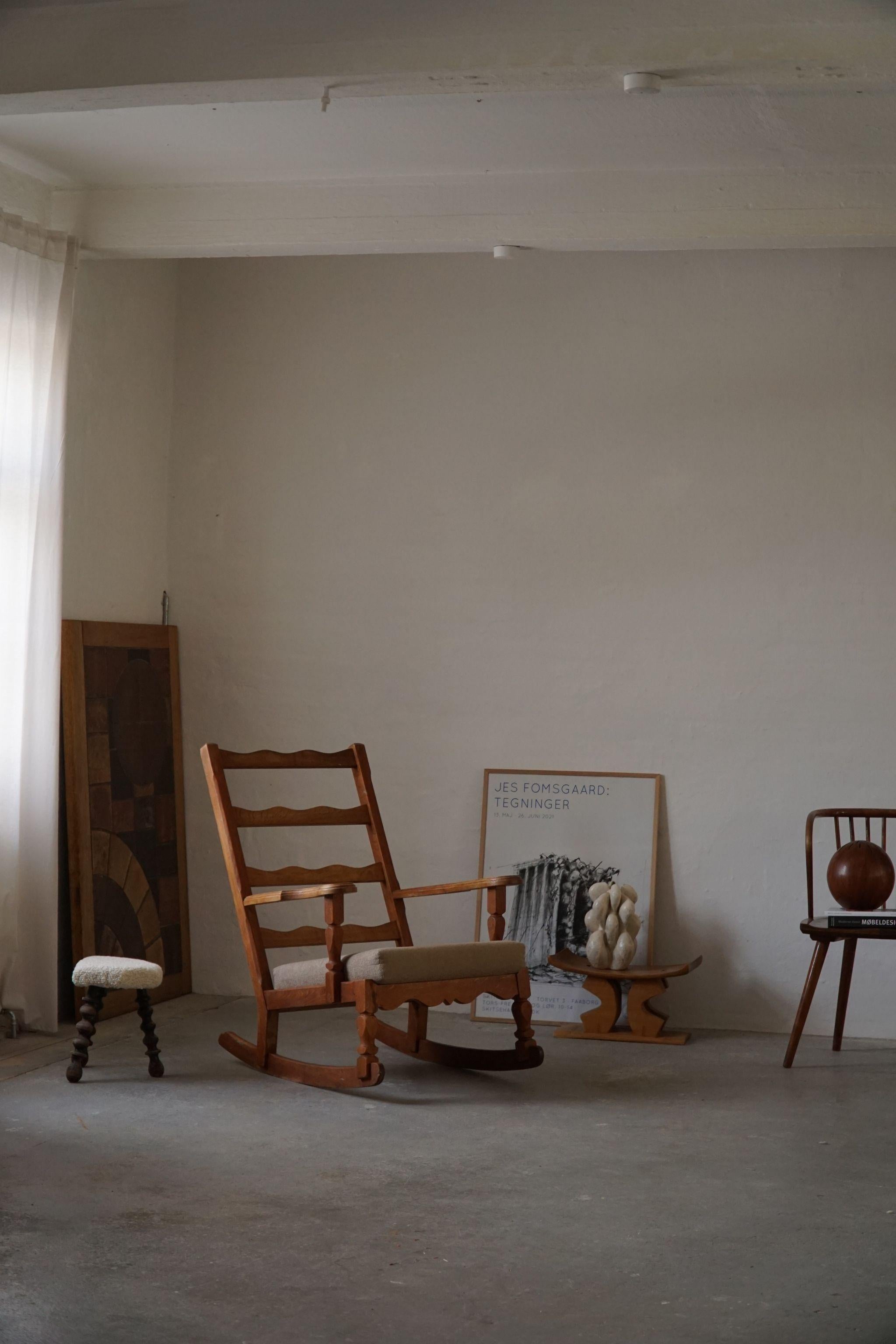 Sculptural rocking chair in solid oak, reupholstered cushions and neck pillow in wool. Made by a Danish cabinetmaker in 1950s. Made in the style of Henning Kjærnulf.

A fine brutalist object in a great vintage condition.

With a heavy focus on