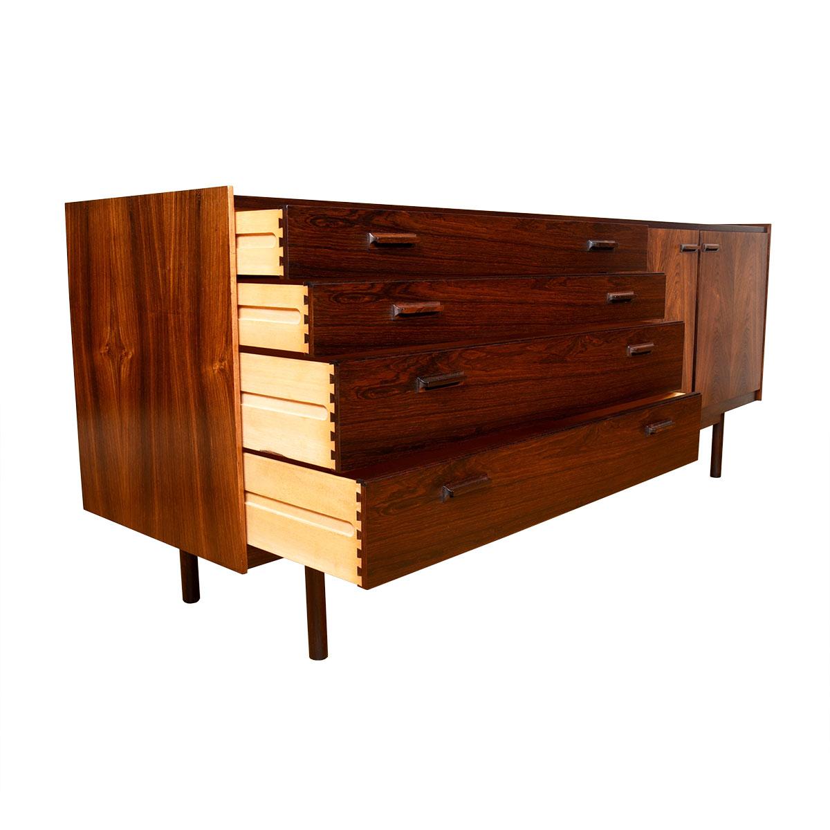 Refined lines and proportions are the defining feature of this incredible credenza in rosewood. Four graduated drawers on the left.
Two doors opening to cabinet storage on the right. Raised lip edge.
Decorative use of the placement of the graining