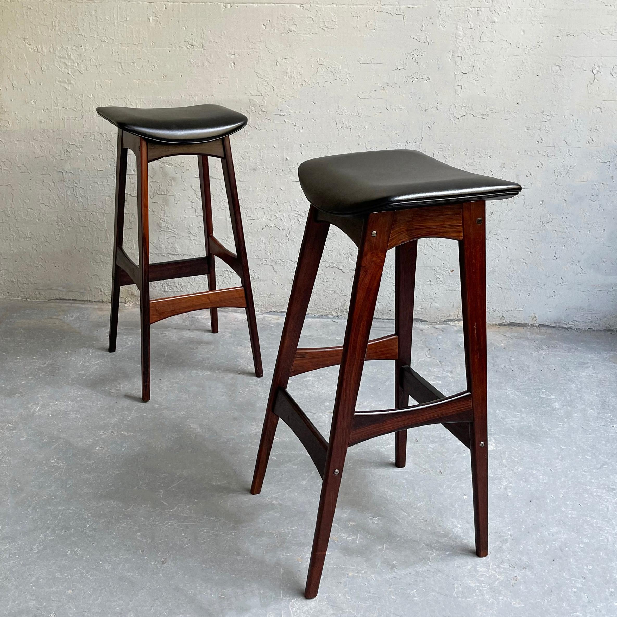 Pair of Danish modern bar stools by Johannes Andersen for BRDR Andersen Vejen feature rosewood frames with black vinyl seats that are 13 inch in depth.