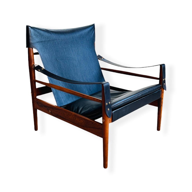 Exceptional “Antilope” safari or hunting lounge chair by Hans Olsen produced by Viskadalens Möbler of Denmark circa 1960s. This chair features an elegant and solid Rosewood frame which holds a beautiful patina tleather seat and arm. The chair is in