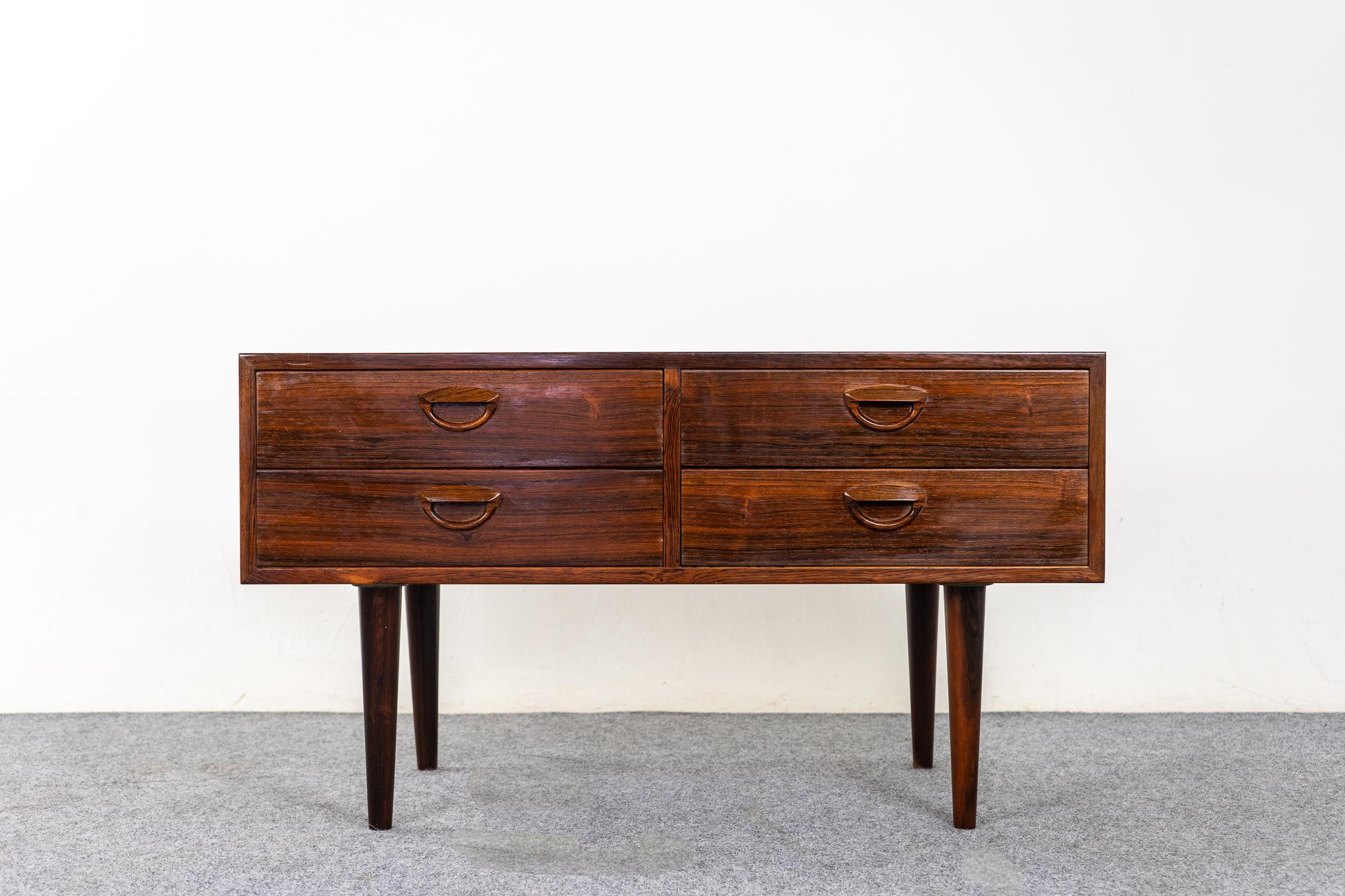 Rosewood Danish modern bedside by Kai Kristiansen, circa 1960's. Beautifully veneered case rests on slender, tapered legs. 4 slim drawers with dovetail construction. Add the extra storage you've always needed!

Please inquire for international and