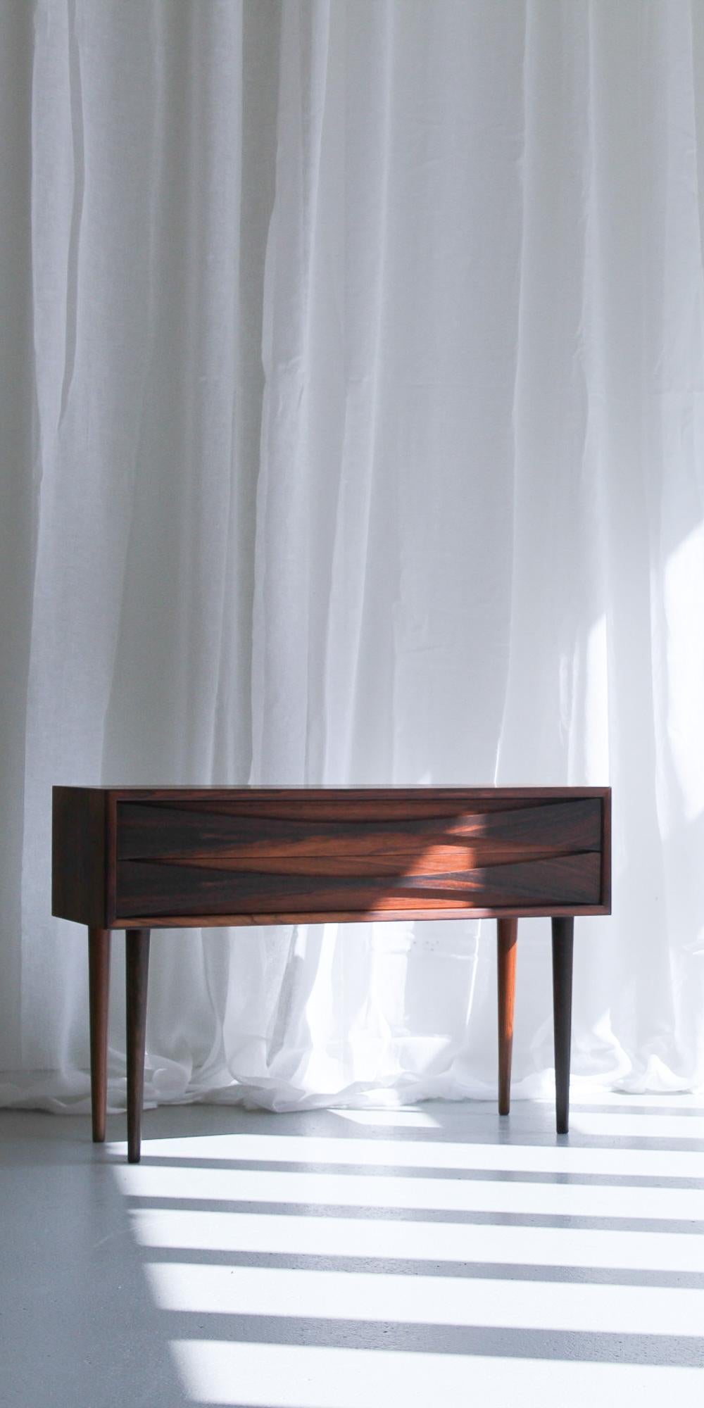 Danish Modern Rosewood Bedside Chest by Niels Clausen for NC Møbler, 1960s.
Scandinavian Mid-Century modern low and wide cabinet with two drawers by Niels Clausen for N.C. Møbler in Odense, Denmark.
Scalloped pulls in the entire width of the
