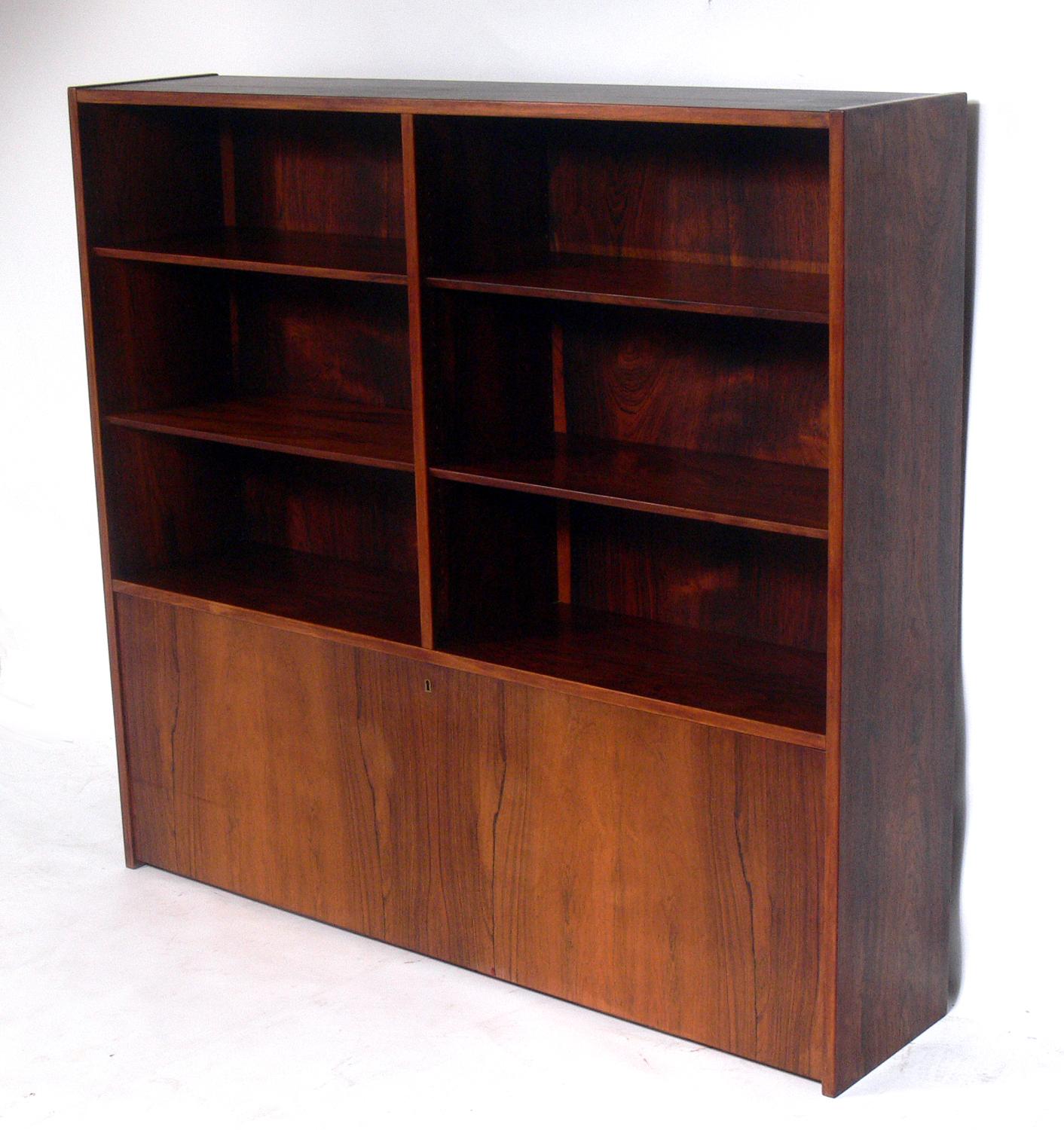Danish modern rosewood bookshelf, designed by Poul Hundevad and retailed by Asbjorn Mobler, Denmark, circa 1960s. Beautiful graining to the rosewood. It offers a voluminous amount of storage with four adjustable shelves at the top and the bottom