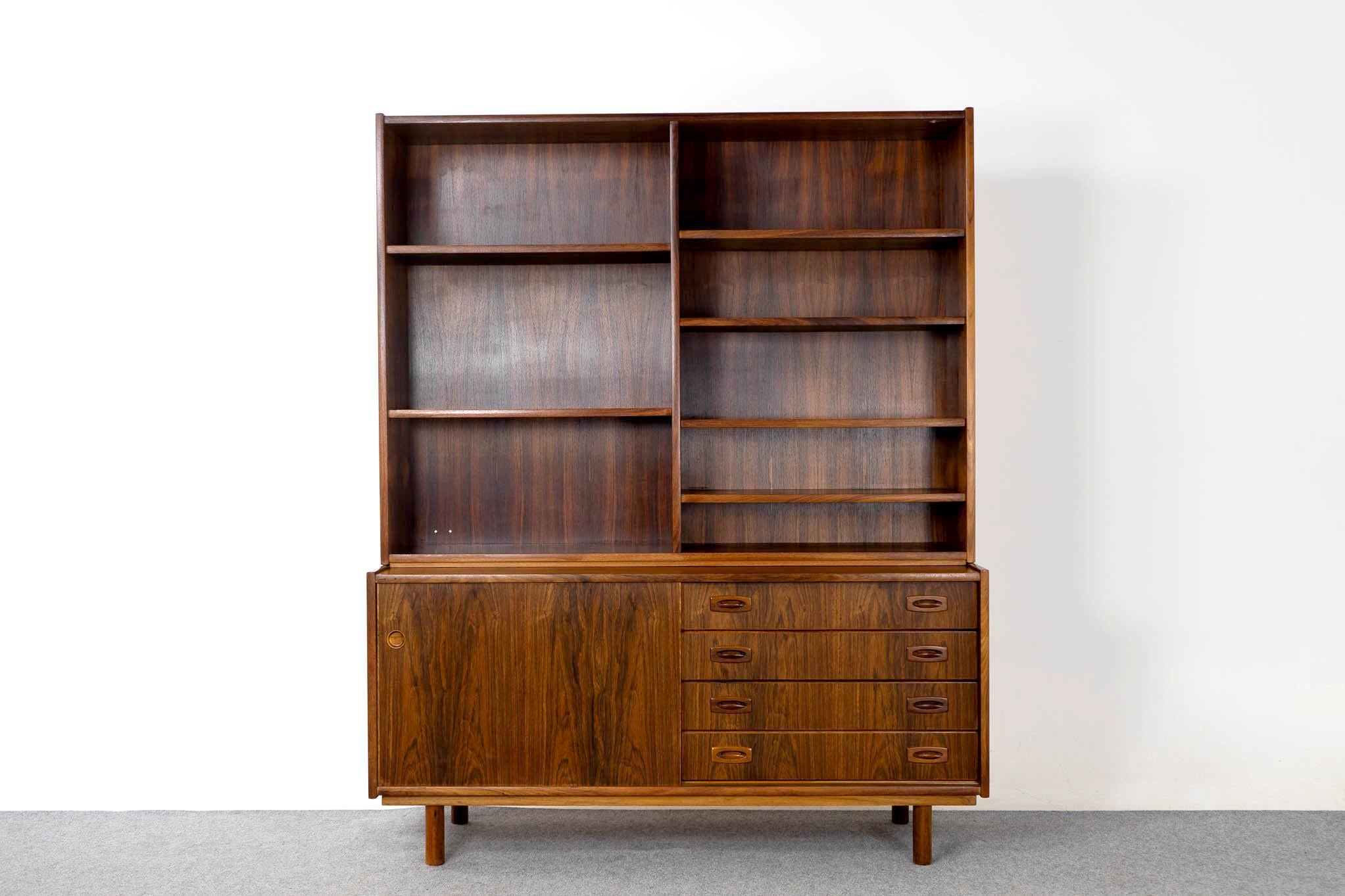 Rosewood Danish modern bookcase/cabinet, circa 1960's. Open bookcase with adjustable shelving, exterior drawers and a sliding door with an interior shelf. Bookcase rests upon lower cabinet, can be used separately.

Unrestored item, some marks