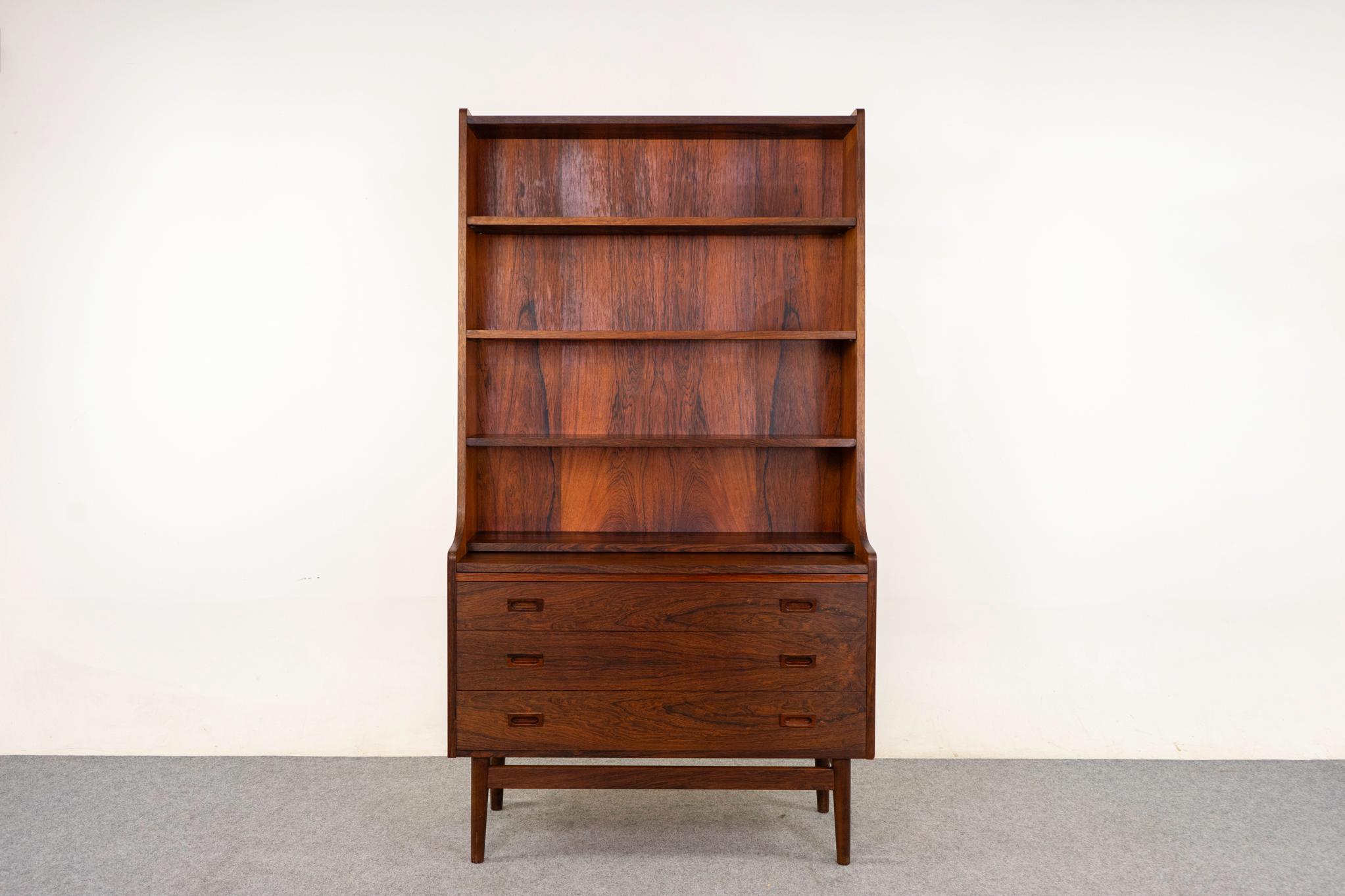 Bücherregal/Schrank aus Palisanderholz, ca. 1960er Jahre. Konisches Bücherregal mit 3 höhenverstellbaren Fachböden. Schiebetürschrank mit verstellbarem Fachboden. Luftiger, schwebender Sockel mit konisch zulaufenden Beinen.

Unrestauriertes Exemplar