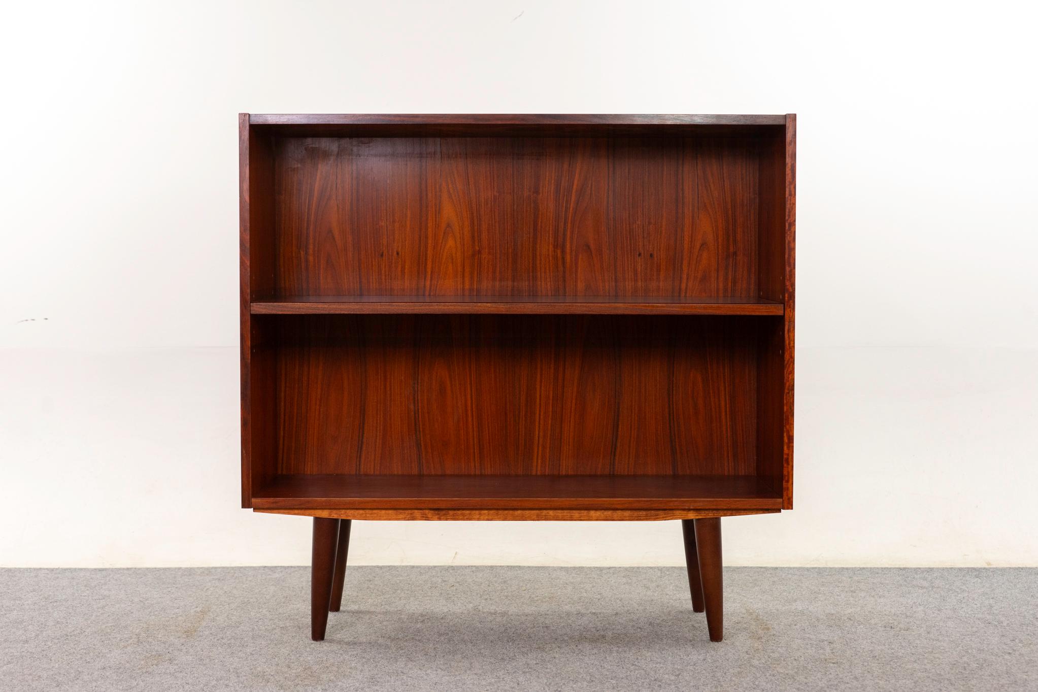 Librería danesa de palisandro, hacia 1960. Chapa de palisandro en tonos intensos, con estante ajustable y patas desmontables.

Artículo sin restaurar con opción de compra en estado restaurado por 200 USD adicionales. La restauración incluye: