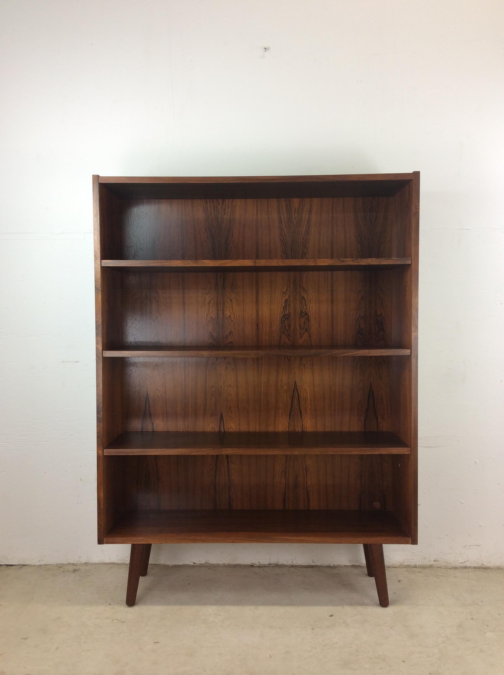 This Danish modern bookcase features pressed wood construction, beautiful rosewood veneer with original finish, three adjustable shelves, and tall tapered legs.  Matching rosewood bookcase available separately. 

Dimensions: 39.5w 11d