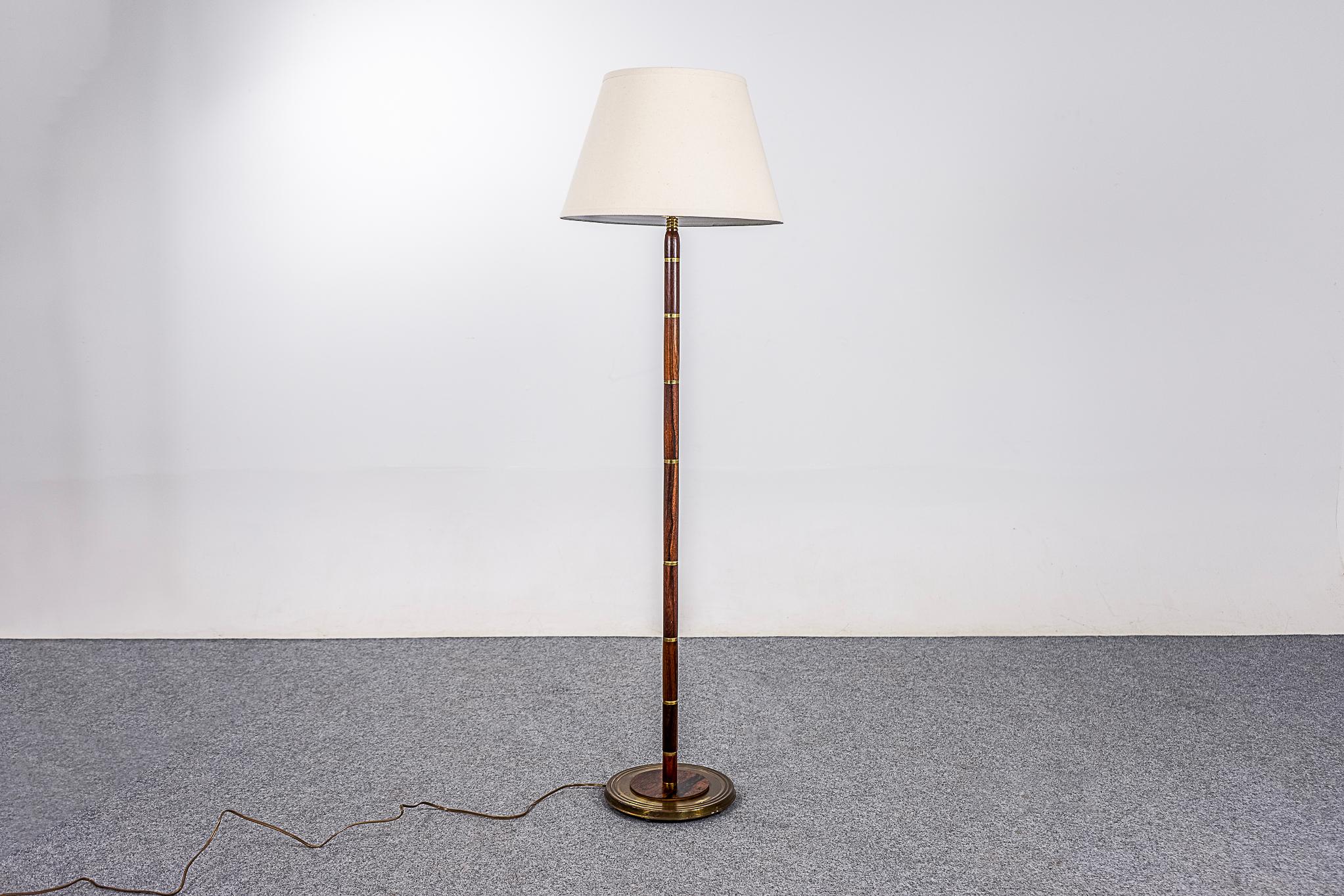 Rosewood and brass Danish floor lamp, circa 1960's. Beautiful solid rosewood construction with metal accents. Custom, quality fabric shade. All new electrical, updated tri-light socket with 3 brightness levels to suit your home. Lovely warm light!