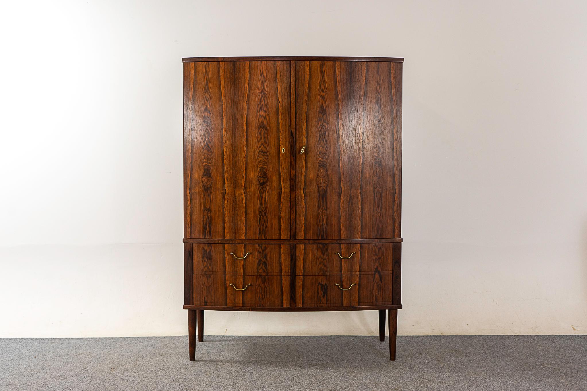 Rosewood midcentury cabinet, circa 1960s. Exceptional book-matched veneer from top to bottom! Locking compartments with 2 adjustable shelves and 4 sleek flatware drawers. Lower drawers with elegant metal handles and dovetailed construction. Quality