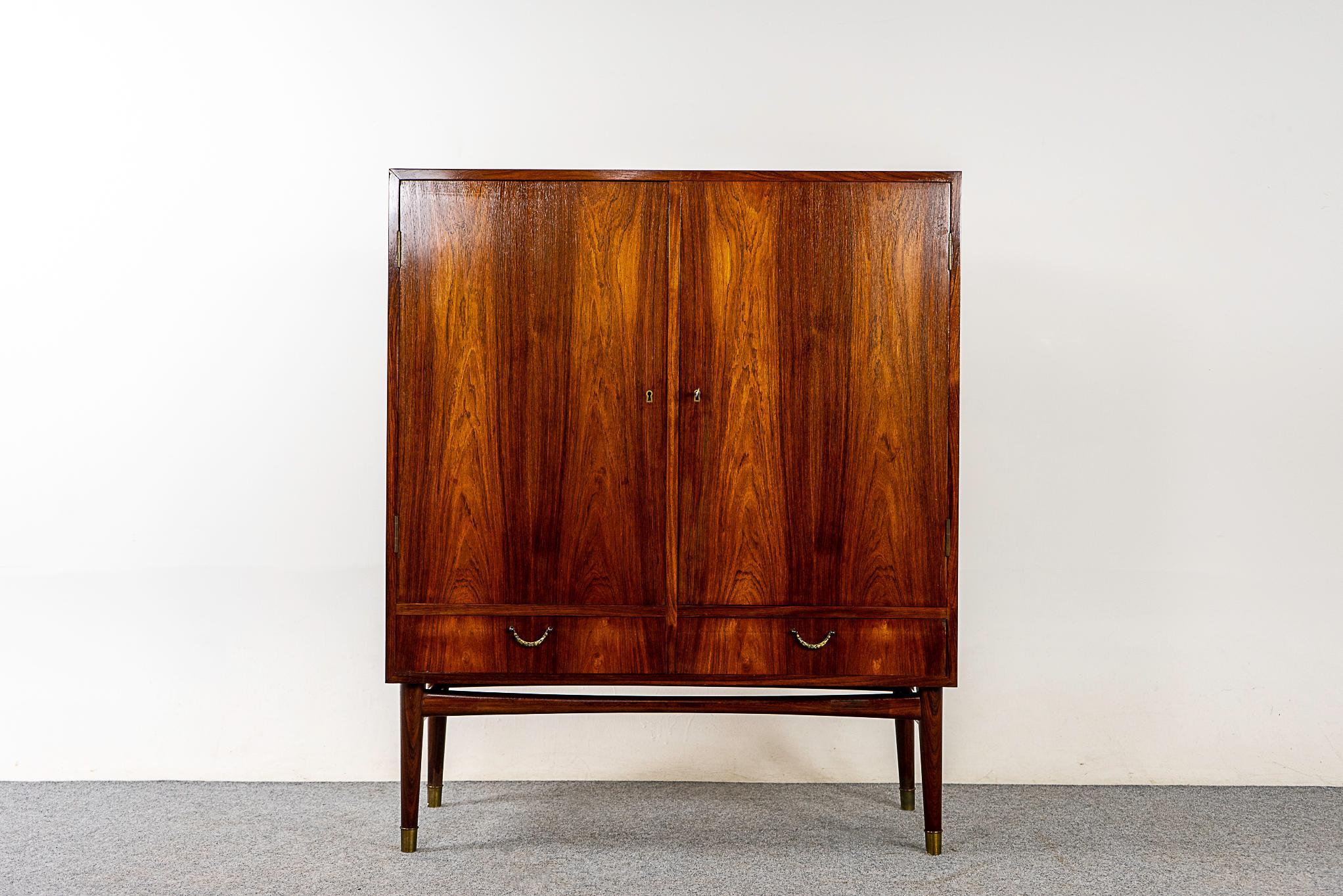Rosewood Danish cabinet, circa 1960's. A combination of exterior doors and drawers offers ample storage. Interior shows adjustable shelving and small interior drawers.

Unrestored item with option to purchase in restored condition for an additional