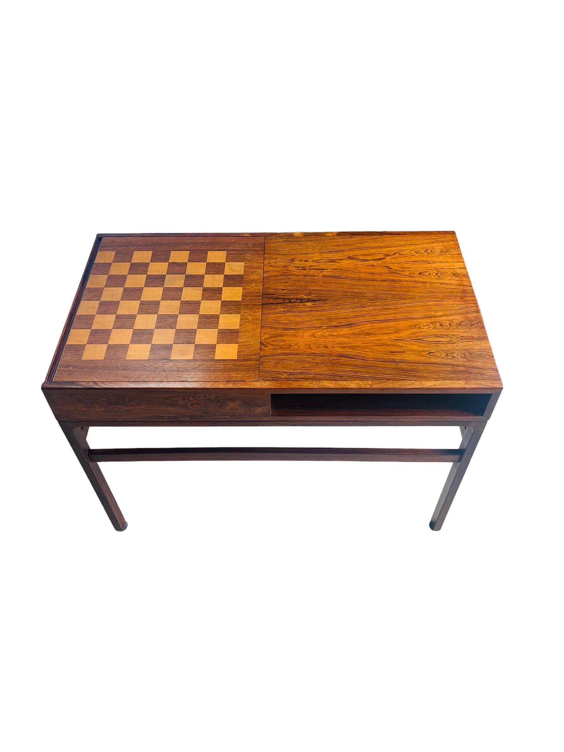 Stunning Danish Modern Rosewood Game table with reversible Chess/Checkers Board designed by Illum Wikkelsø. This beautiful table has space for magazines and storage space under the sliding game board. The table is in good vintage condition with