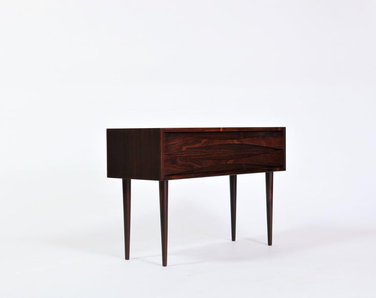 Beautiful and rare low rosewood chest/cabinet by Niels Clausen for NC Mobler, Odense, Denmark. Produced in the 1960s. Two drawers with scalloped pulls and solid tapered legs.