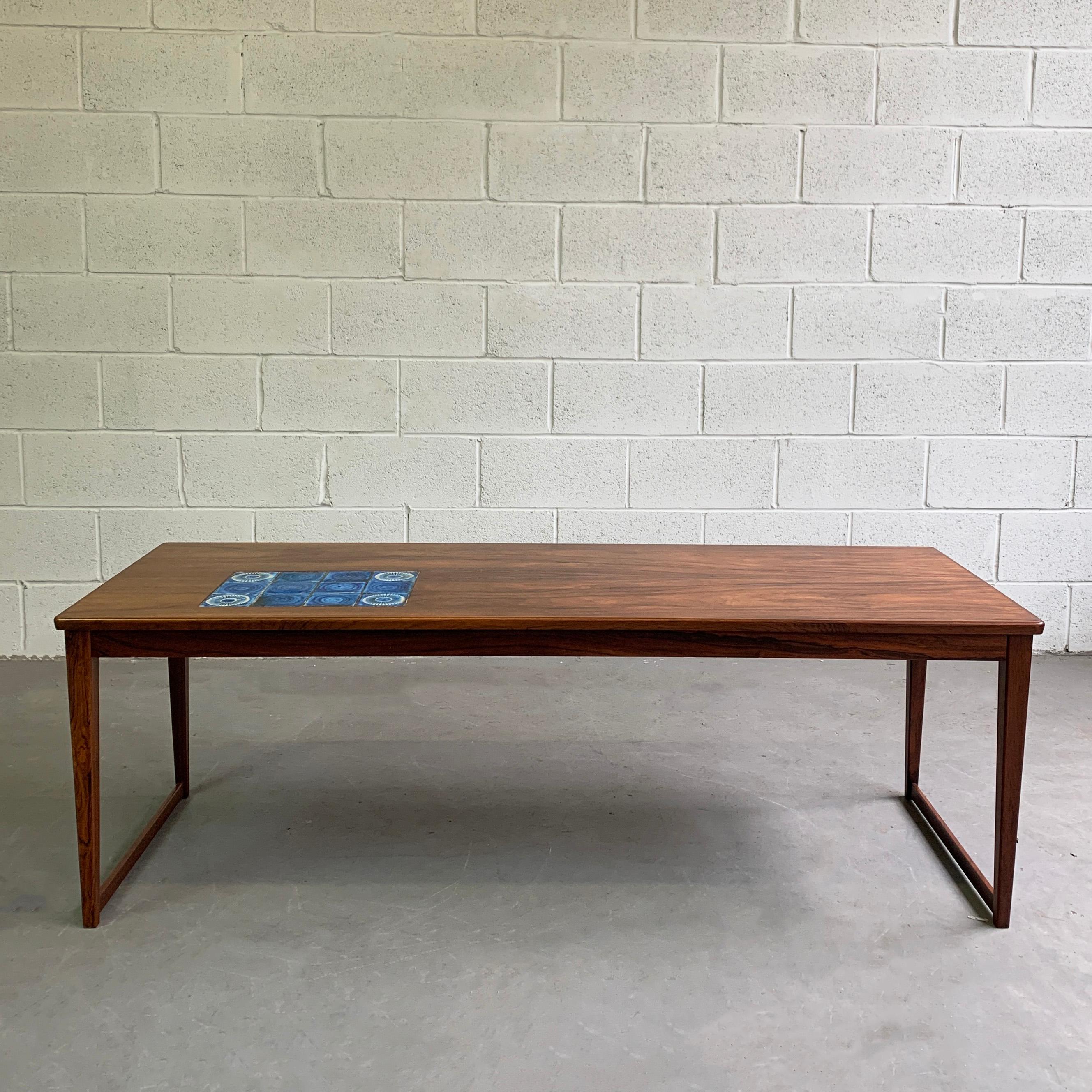 Danish modern, rosewood, coffee table features sleigh legs and a ceramic tile inlay reminiscent of Bitossi Rimini blue art pottery. Perfect as a high coffee table or low console table.