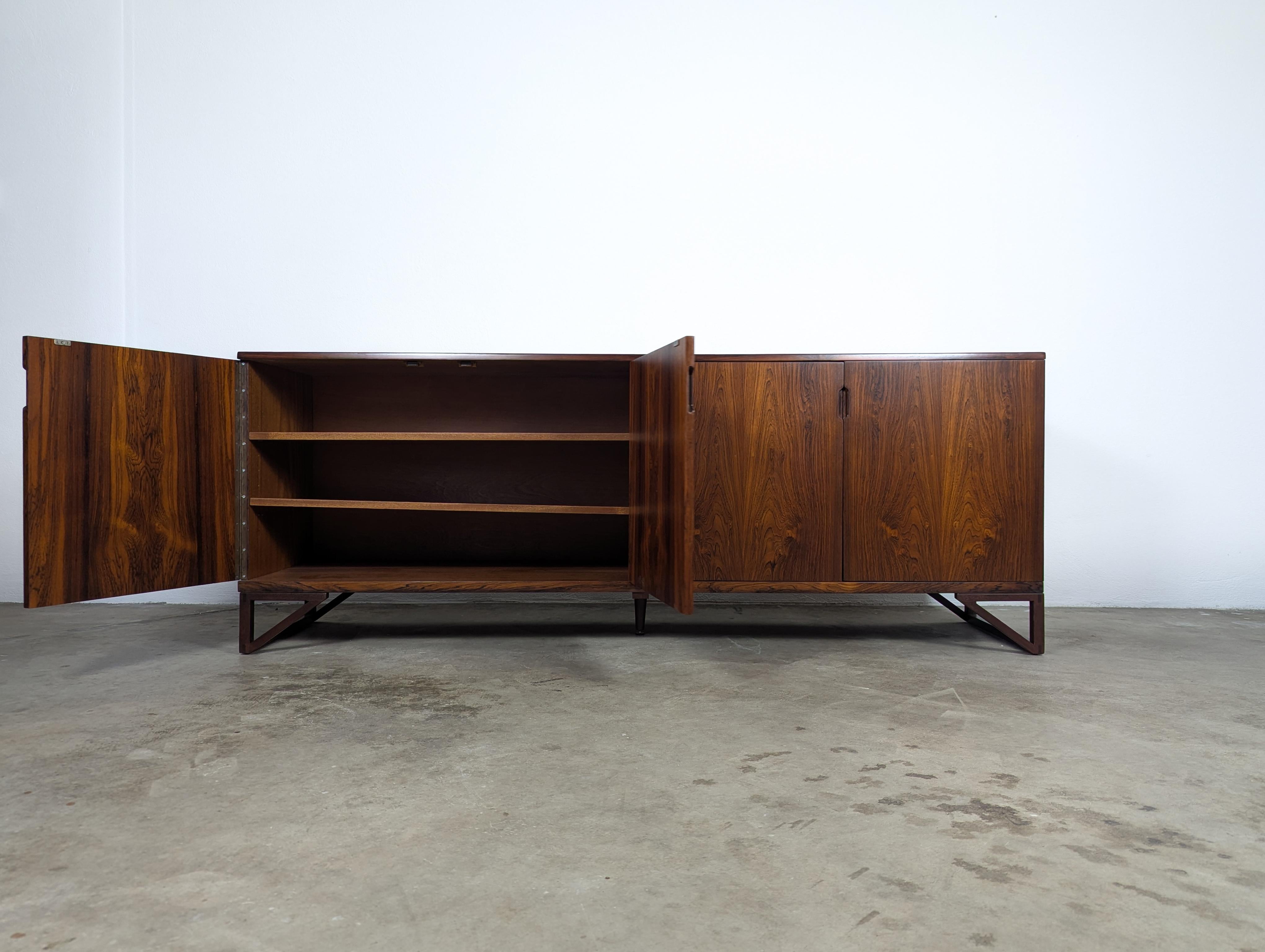 Eleva l'arredamento della tua casa con questo squisito mobile / credenza vintage in legno di palissandro Mid Century Mobler del famoso designer Svend Langkilde per Langkilde Mobler, realizzato negli anni '60 in Danimarca. Questo pezzo raro è stato