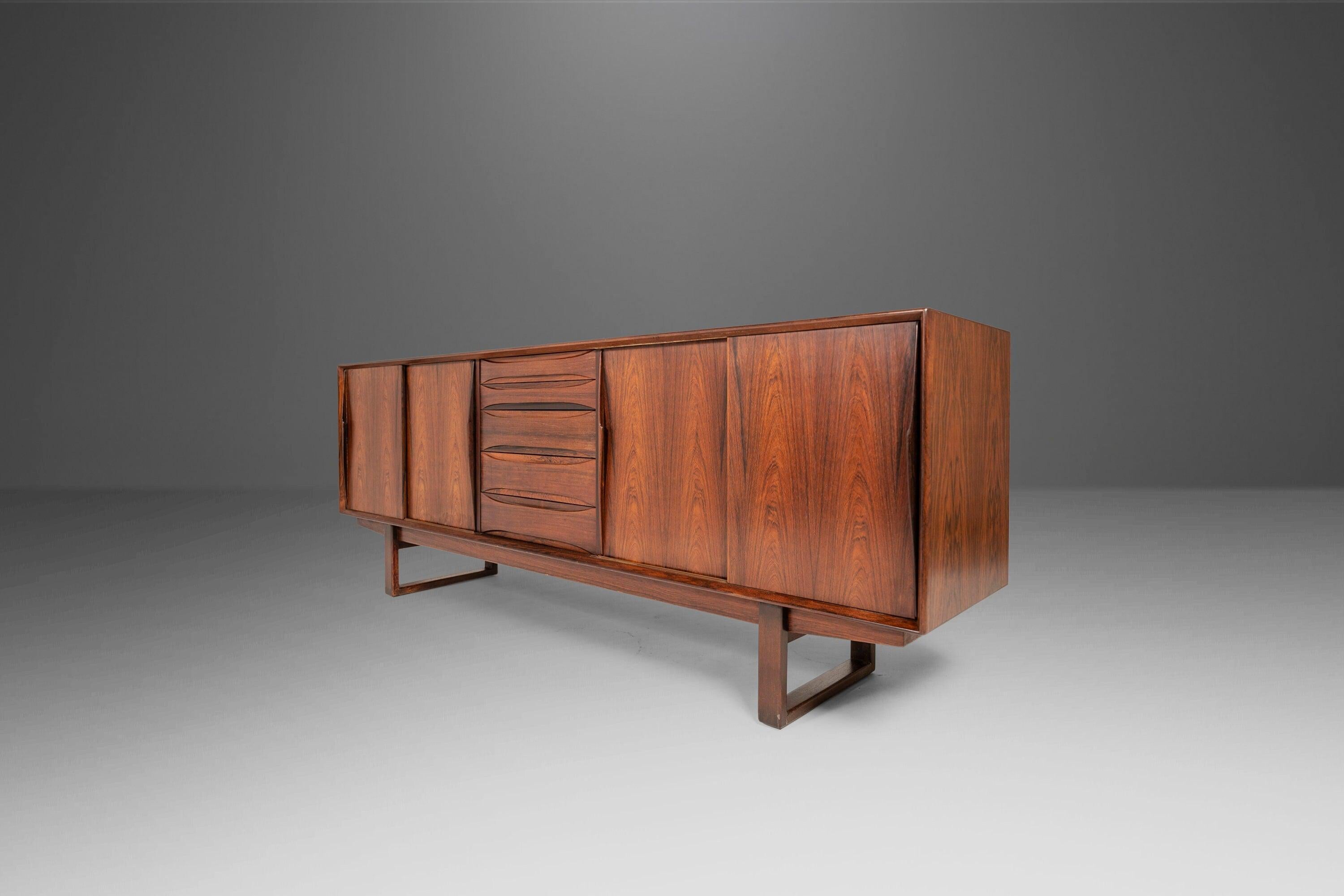 Equal parts beauty and functionality this exquisite credenza, attributed to Arne Vodder, is the epitome of 'functional art'. Constructed of a mix of solid and veneered Brazilian rosewood with exceptional variegated woodgrains unique to Brazilian
