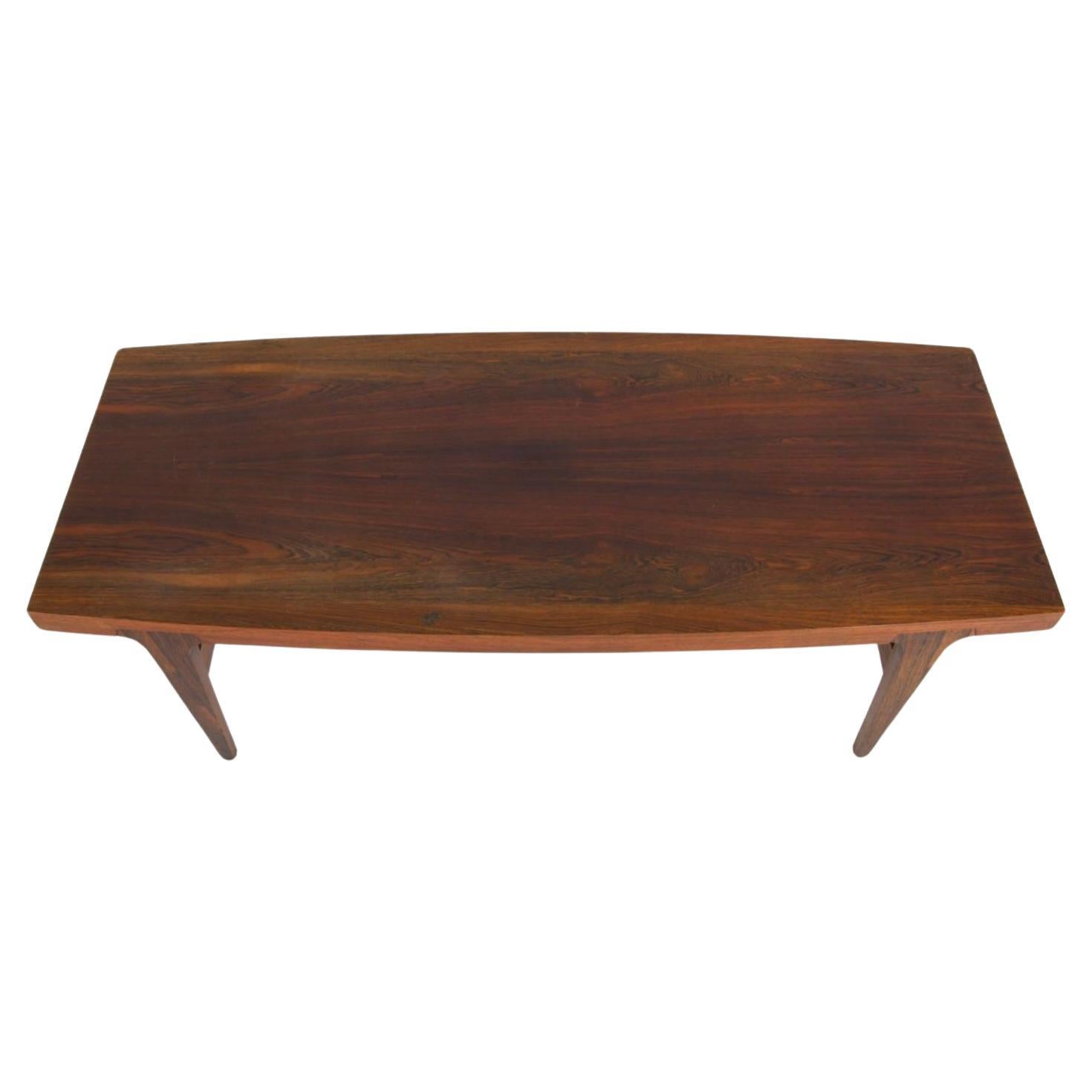 Table basse moderne danoise en palissandre, dans le style de Johannes Andersen. Belle table basse en palissandre de forme incurvée sur pieds fuselés. Fabriqué au Danemark vers 1960. 

Dimensions : L 63