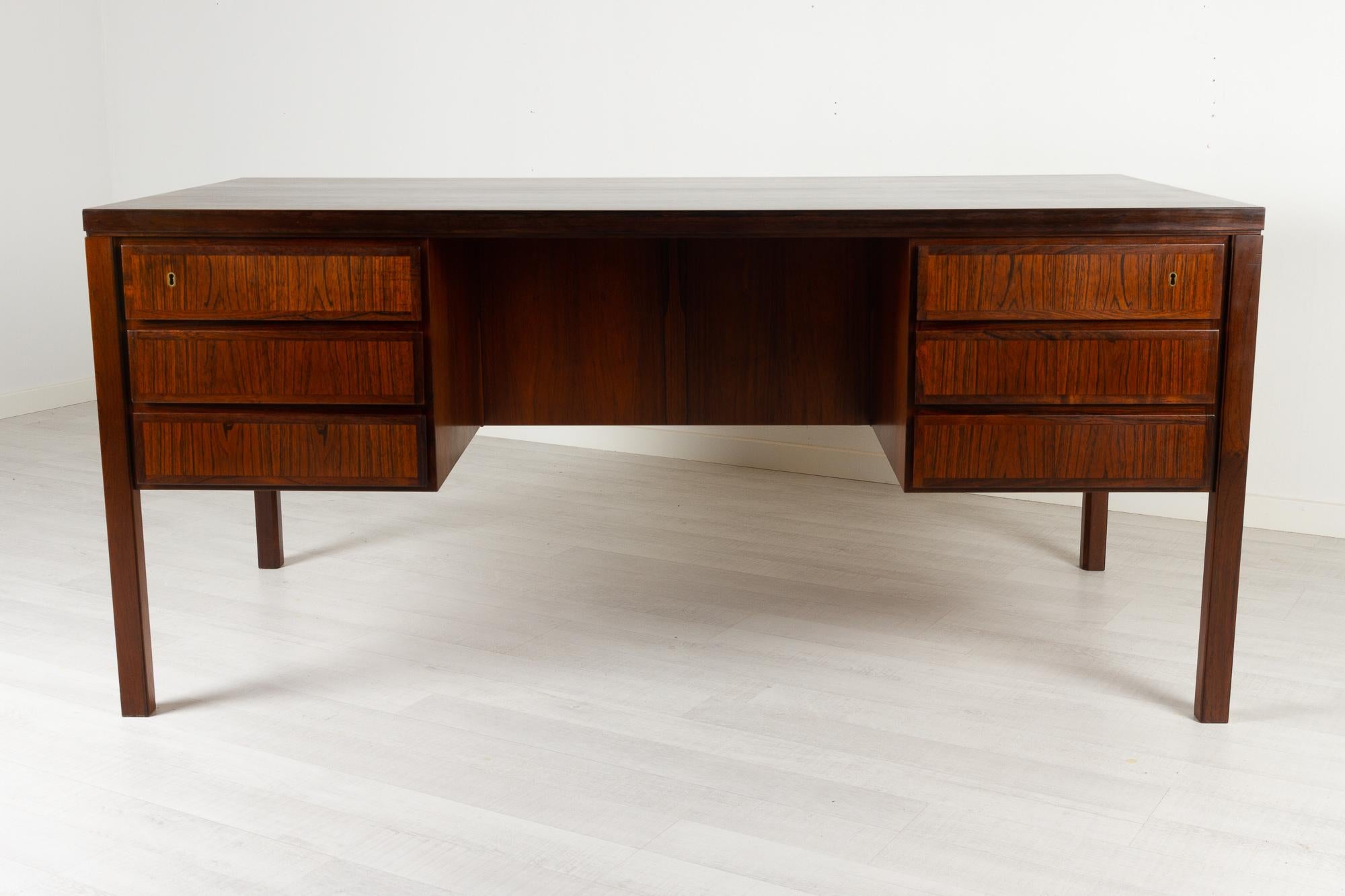 Vintage Danish Mid-Century Modern freestanding Rosewood desk by Omann Jun. 1960s
Large executive free standing writing desk in Rosewood Model No. 77 made by Omann Jun, Denmark.
Minimalistic cubic design with clean lines. 

Six drawers in front.