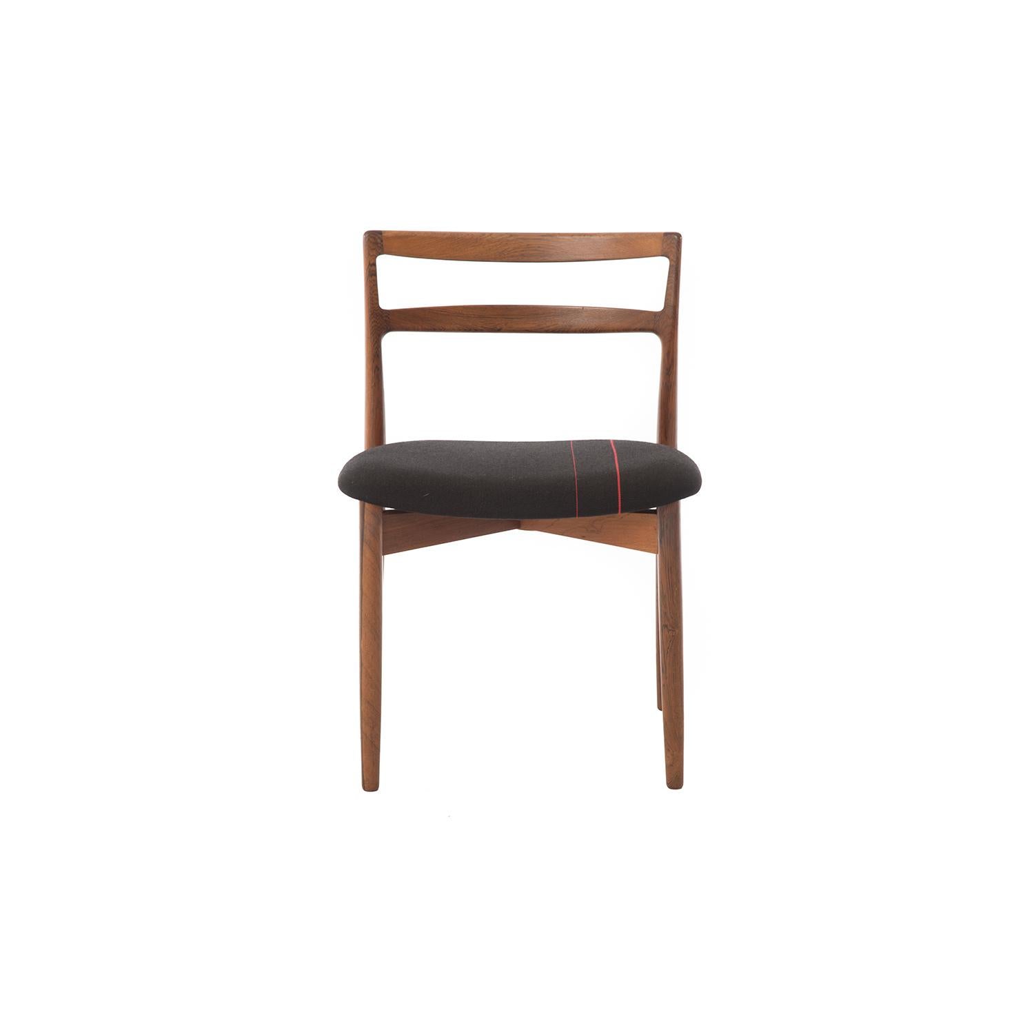 This set of 6 Harry Østergaard rosewood dining chairs feature a sleek ladder back design, which is offset by a wider and more plush seat, upholstered in mercerized wool, with slight racing stripes.