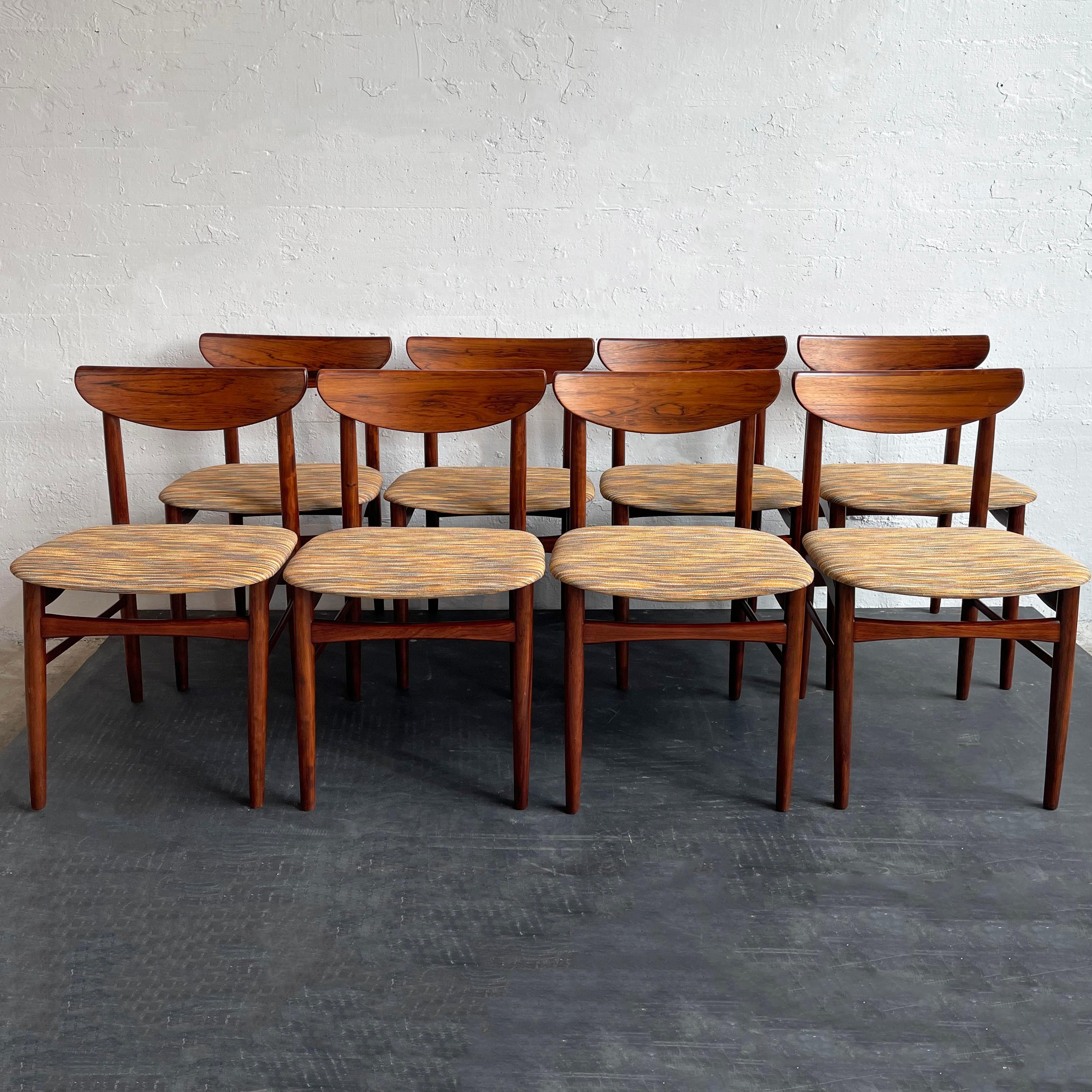 Set of 8, Danish modern dining chairs designed by Kurt Østervig for K.P. Møbler, 1959, Denmark. These elegant chairs feature beautifully grained, Brazilian rosewood frames with sculpted backrests and newly upholstered seats in a multicolor uneven
