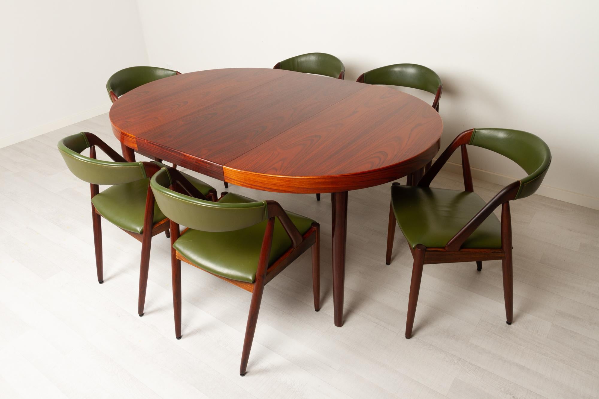 Danish modern rosewood dining room set by Kai Kristiansen for Schou Andersen Denmark 1960s
Danish mid-century modern extendable dining table with six chairs. 

Chairs:
Set of six Danish Mid-Century Modern dining room chairs in solid Rosewood.