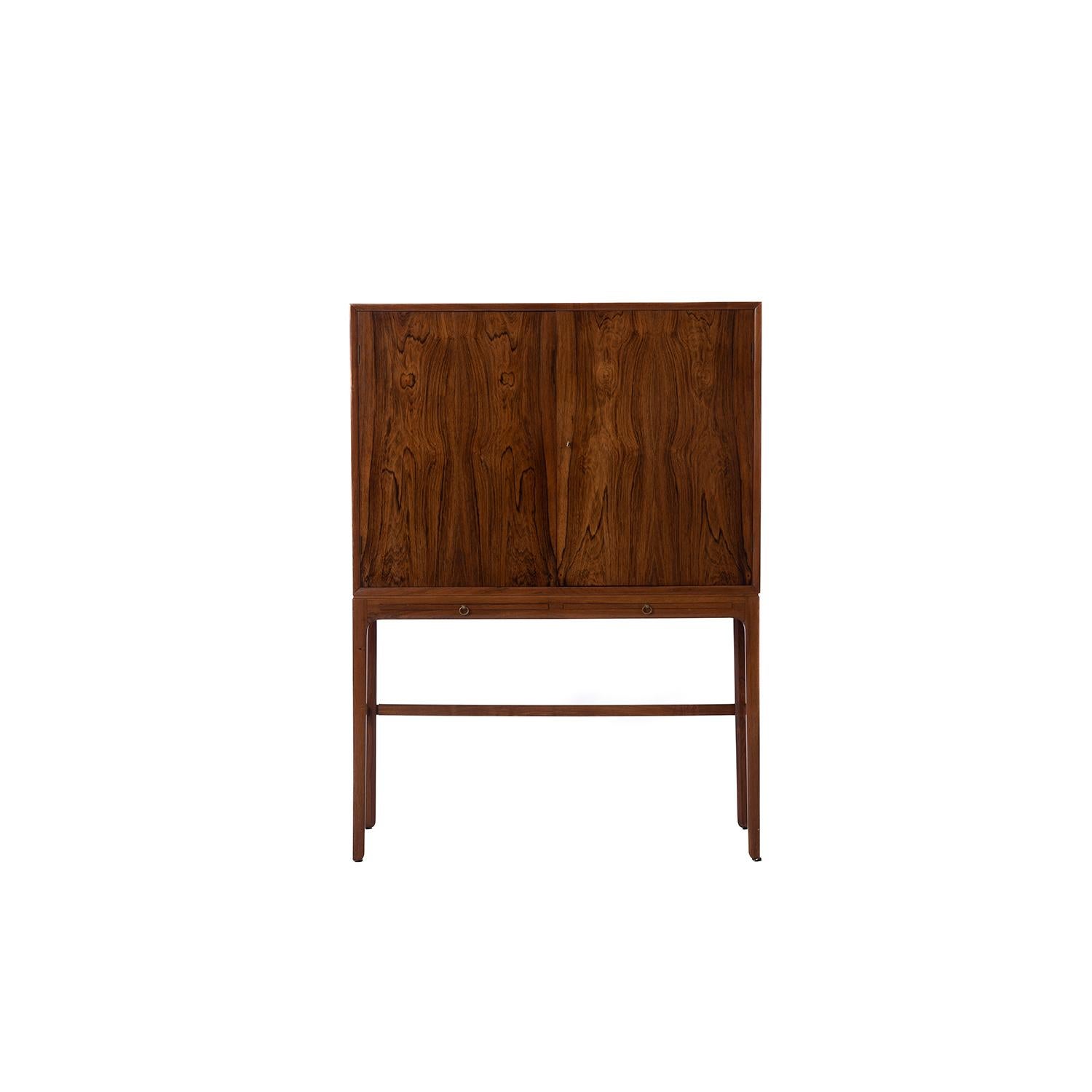 A beautiful and hard to find Rosewood occasional cabinet designed by Ole Wanscher. Tall and elegant this piece features more traditional Scandinavian cabinet making techniques and design. This piece will be cleaned up upon purchase.

Professional,