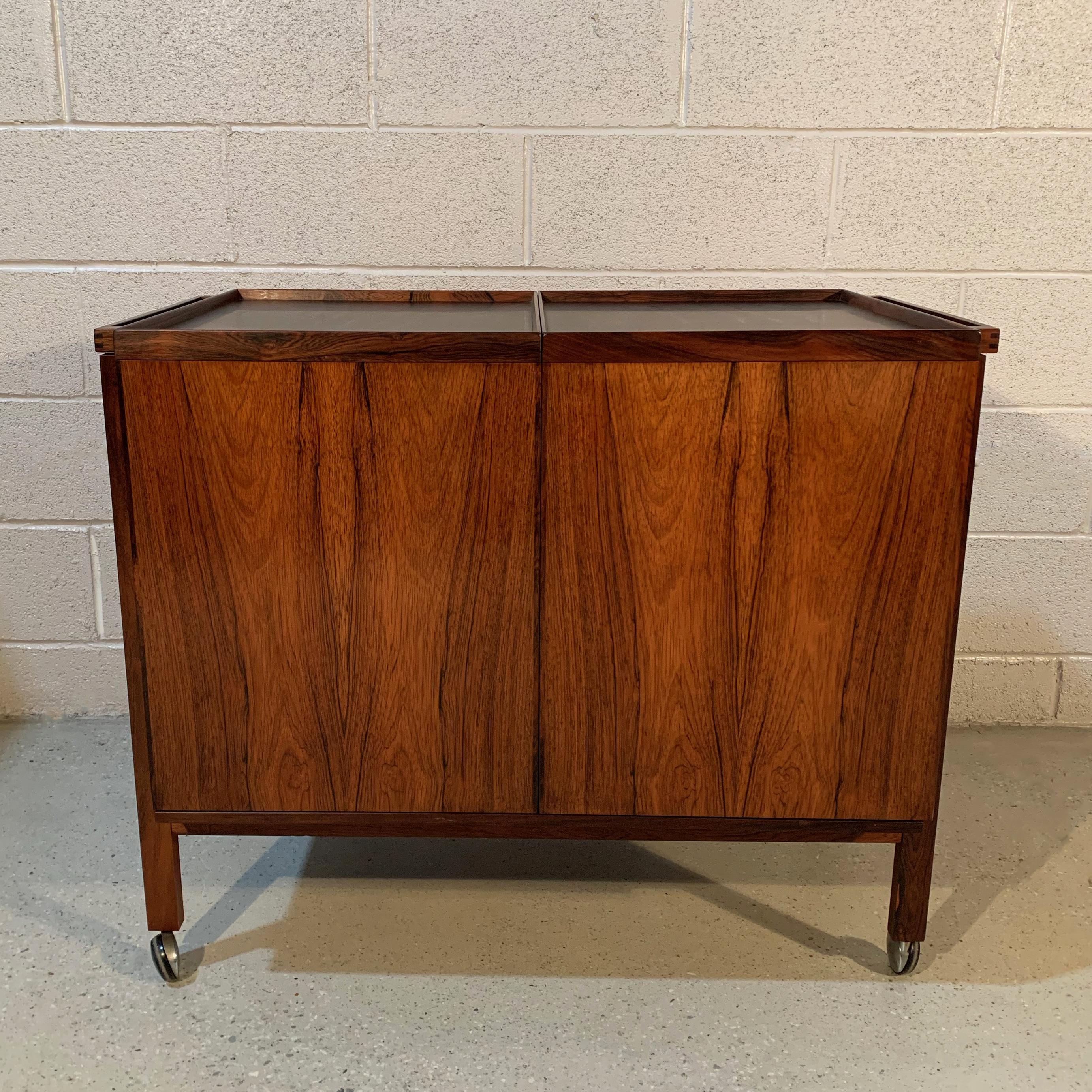 Danish modern, rolling, rosewood bar cart by Niels Erik Glasdam for Vantinge Mobelindustri, slides open to reveal 3 divided sections for bottles and a glass ledge above for glasses storage. The black laminate surface is ideal for mixing and serving.