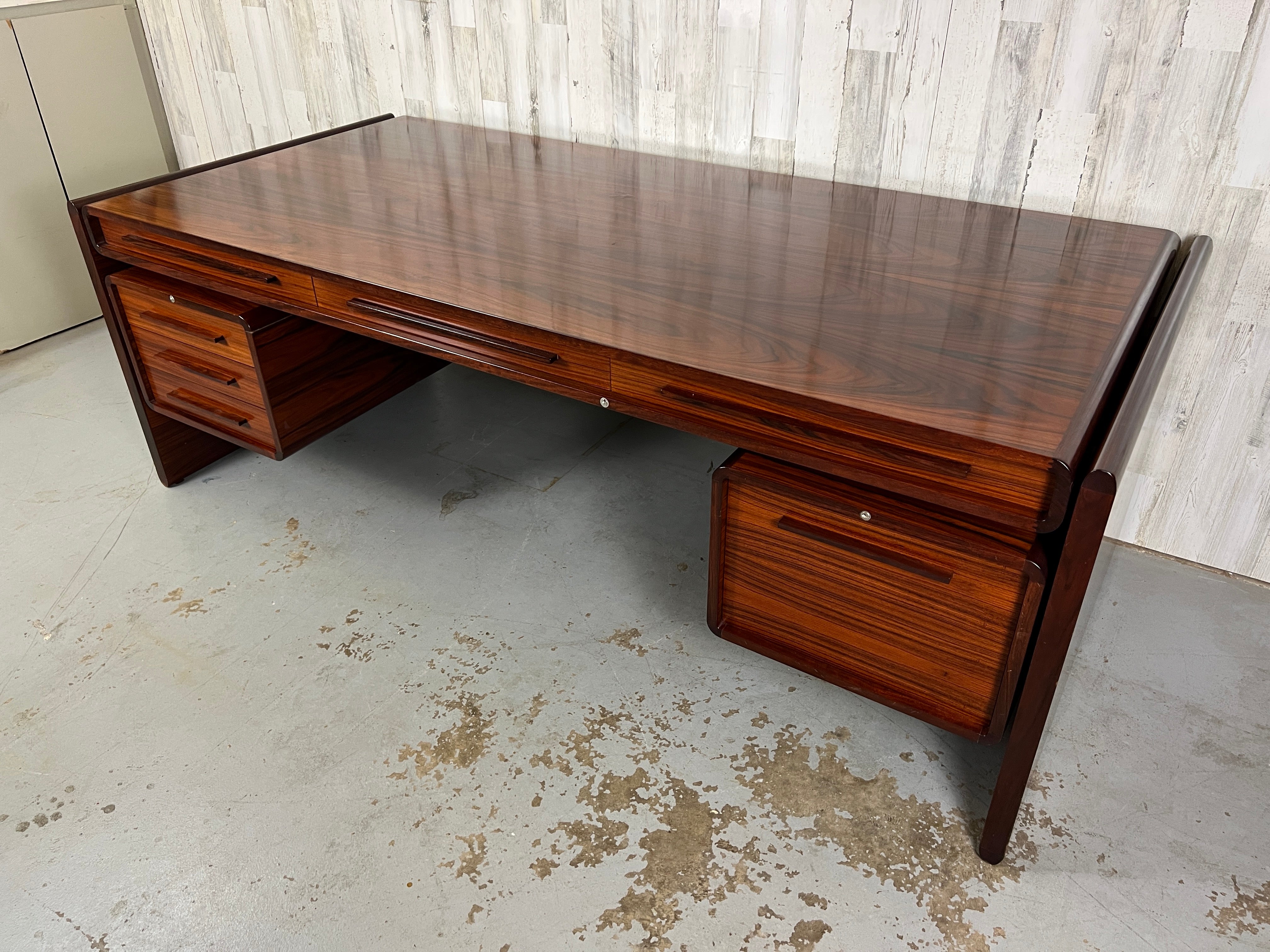 Dyrlund rich rosewood executive desk with a finished back that makes it easy to float in an office. Tons of drawers for storage for the business person.