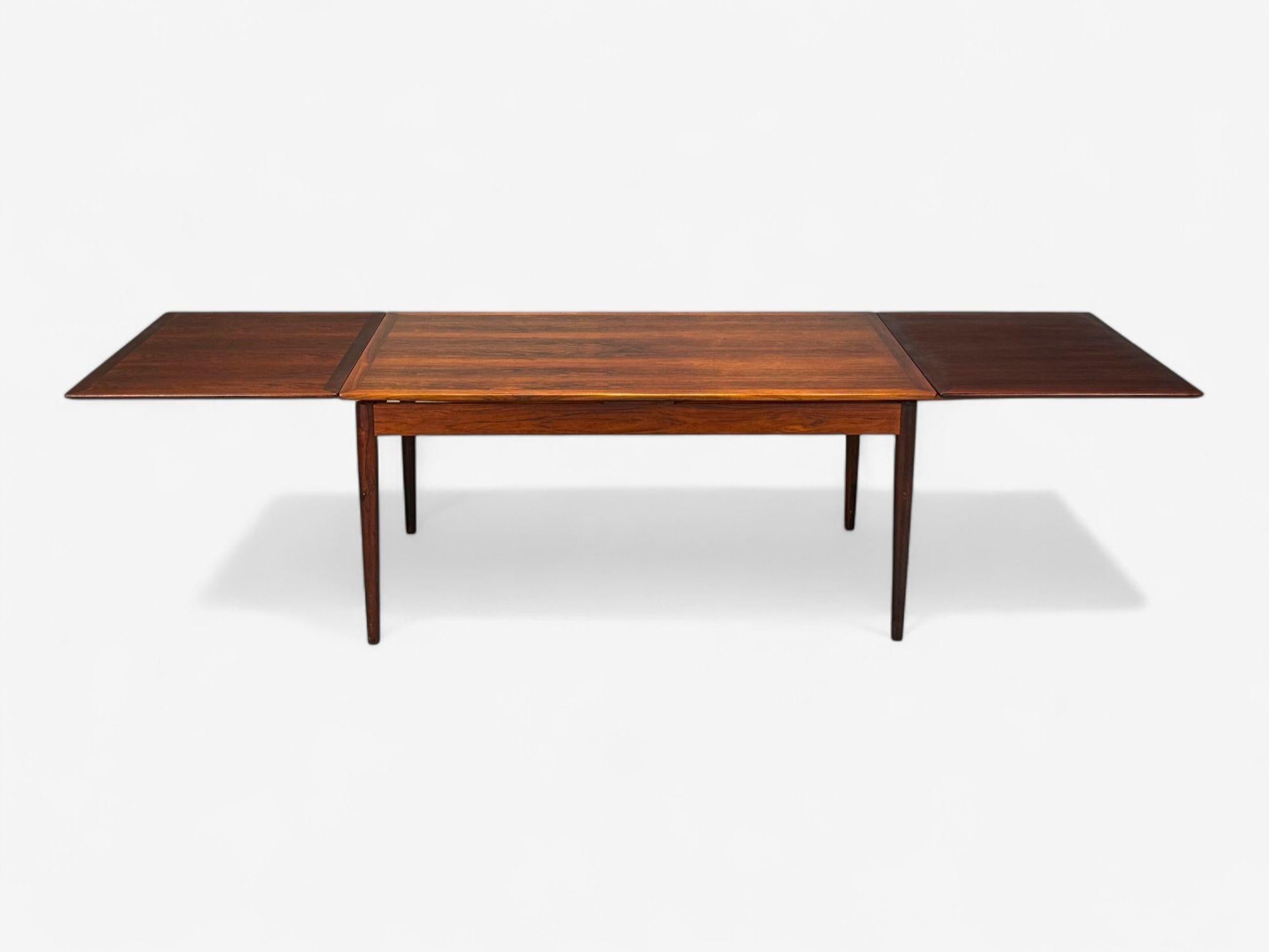 Mesa de comedor extensible, danesa, moderna, de palisandro, Dinamarca, años 60

Mesa de comedor extensible de palisandro, diseñada y fabricada en Dinamarca hacia la década de 1960. Este ejemplo tiene dos hojas ocultas y se extiende hasta un total de