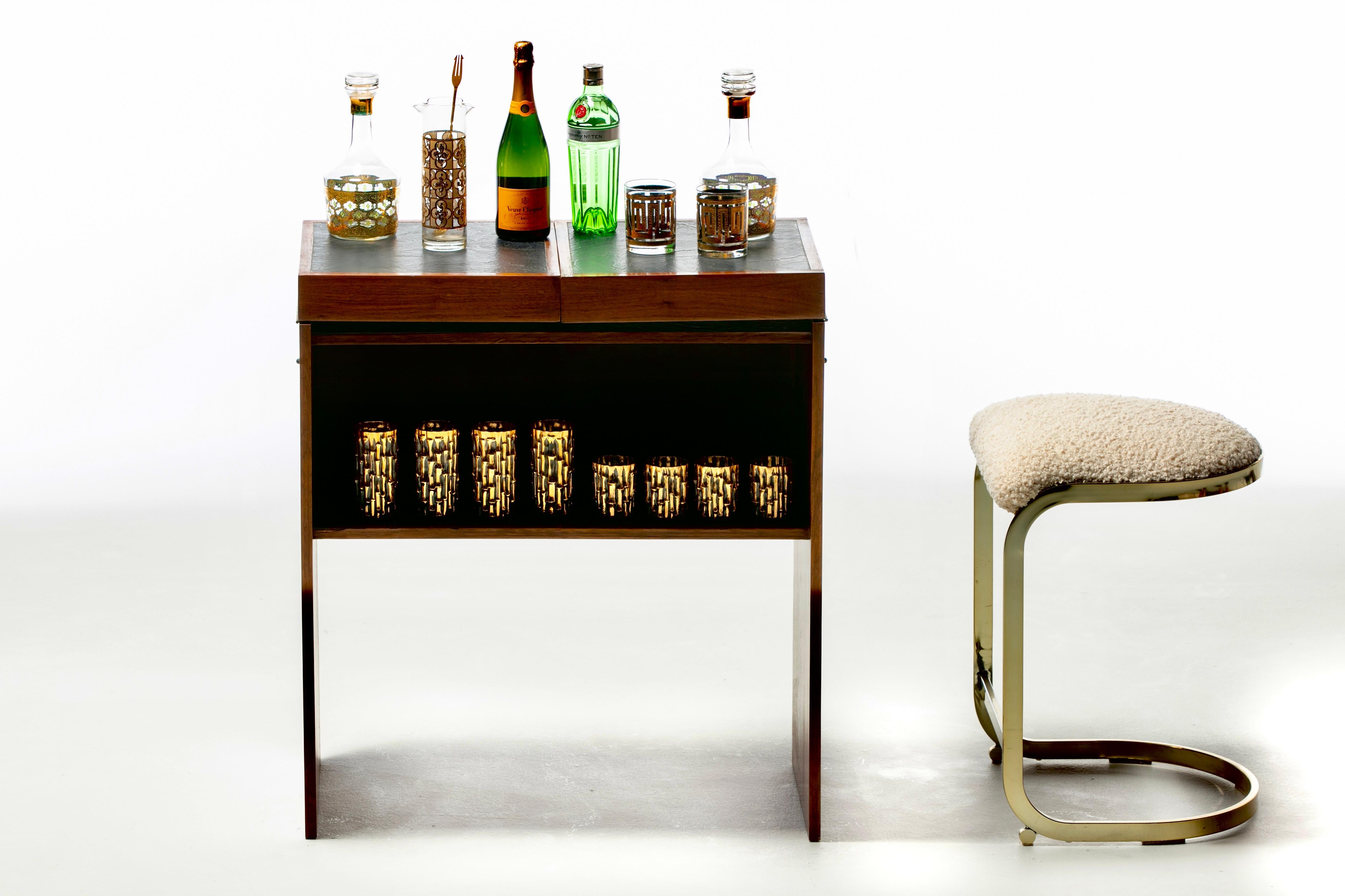 Mid Century Danish Modern 1960s Rosewood Dry Bar goes from proper to party in just two flips. When not in use, the bar is understated and unassuming in keeping with Danish Modern style. When the clock strikes Cocktail Hour, it easily transforms into