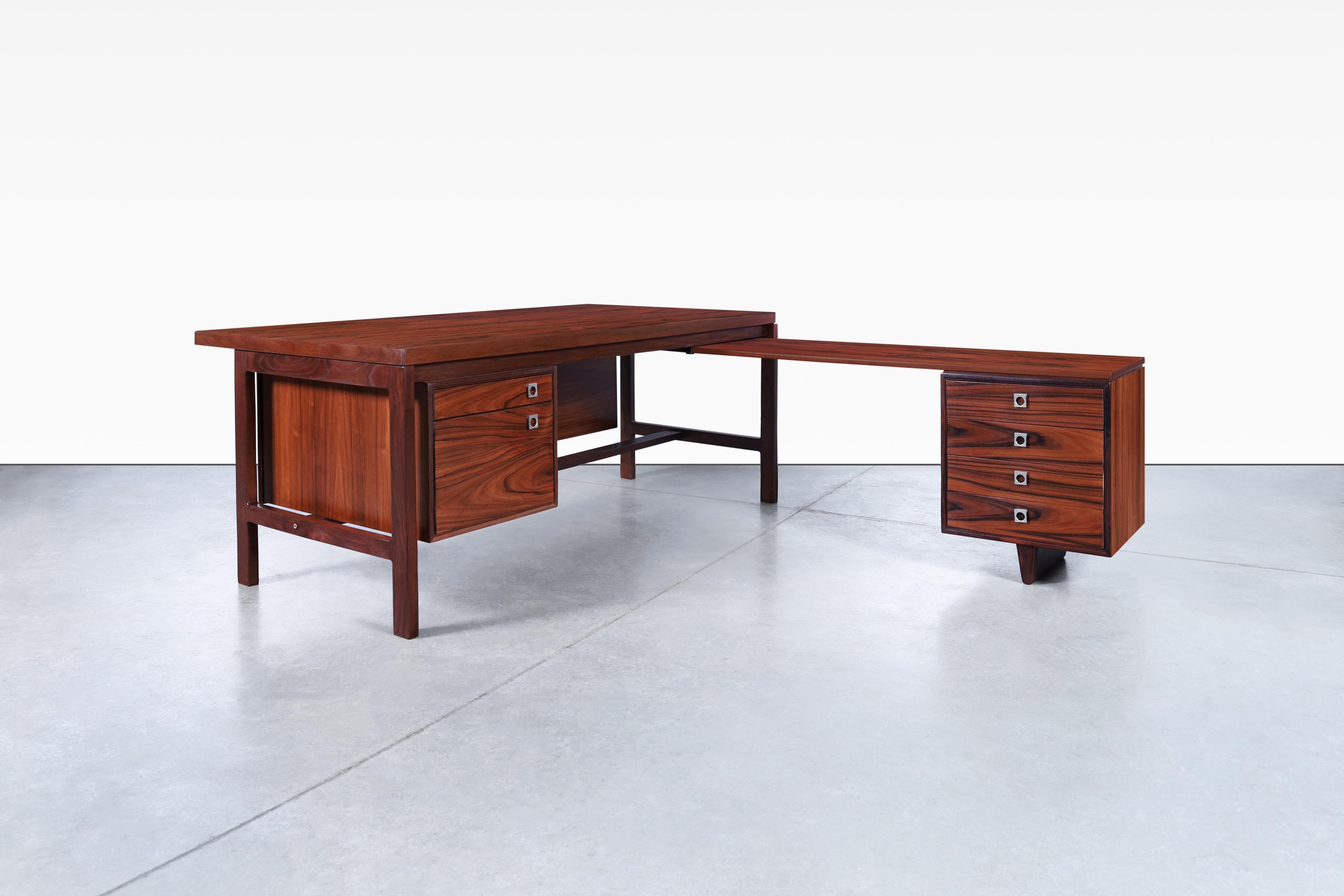 Looking for a statement piece to complete your home office or workspace? Look no further than this stunning Danish modern rosewood L-shaped desk designed by Arne Vodder for H.P. Hansen in Denmark in the 1960s. The unique L-shape design is both