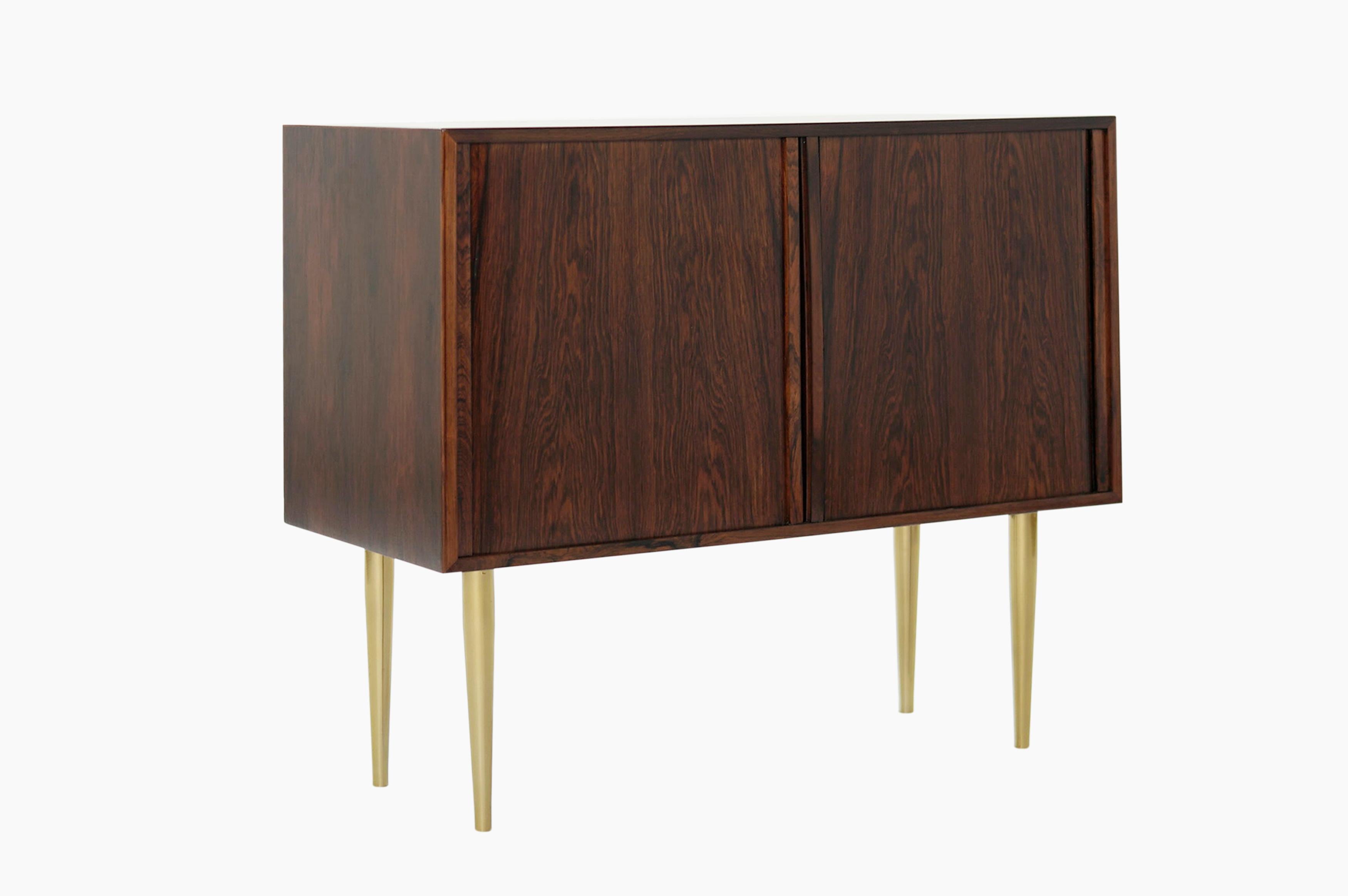 An exceptional cabinet made from rosewood, featuring tambour doors and brass legs.