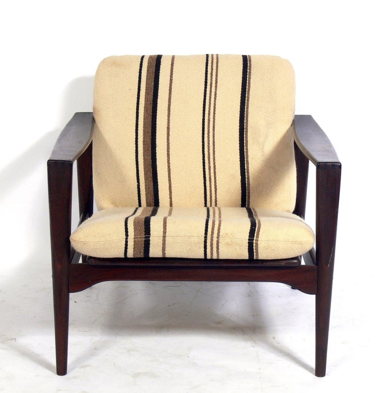 Danish modern rosewood lounge chair, Denmark, circa 1960s. It retains it's original striped wool upholstery. The beautifully grained rosewood has been cleaned and Danish oiled. The arms exhibit interesting finger joinery at the armrests.