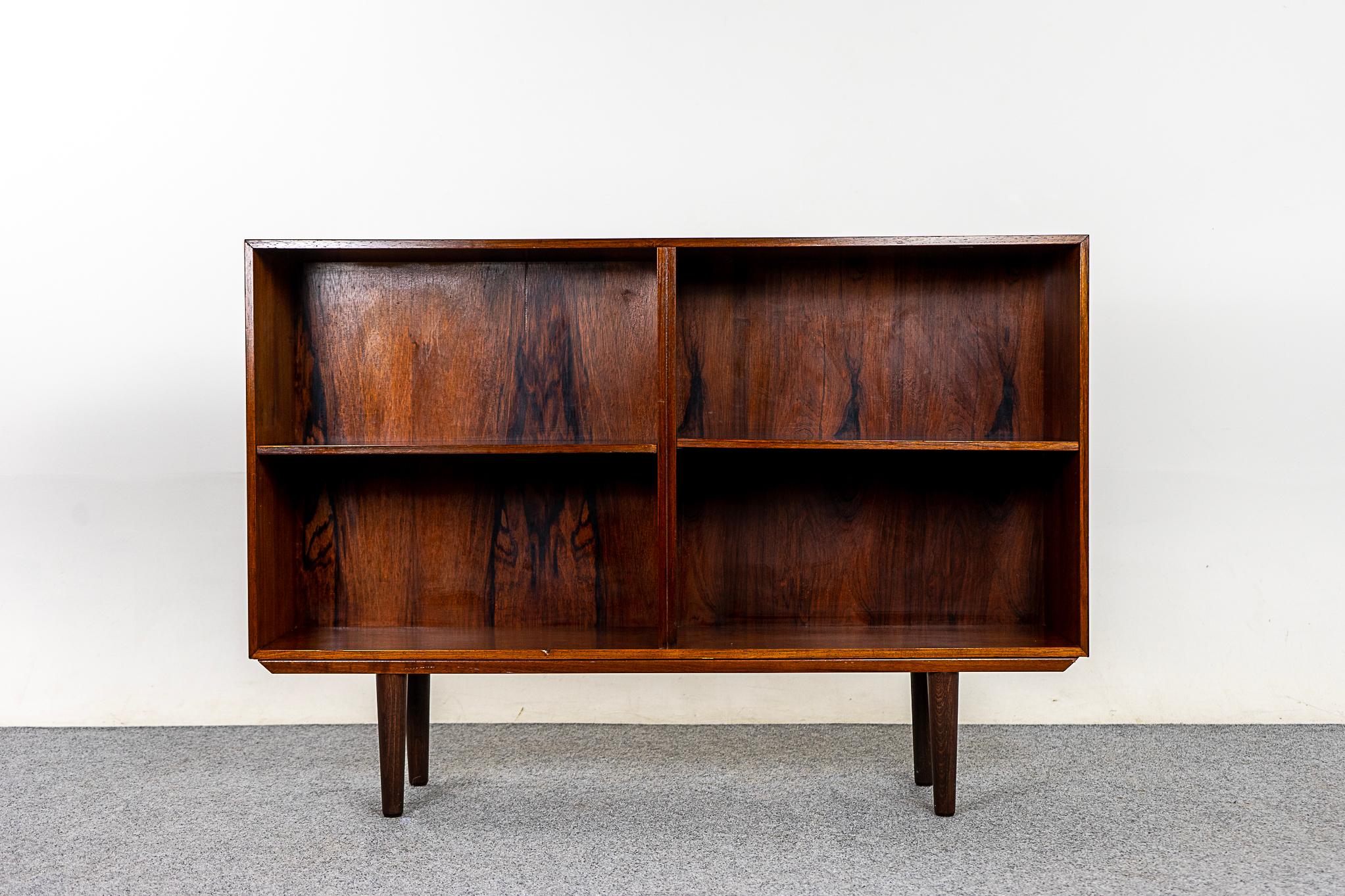 Rosewood Danish bookcase circa 1960's. Low profile open bookcase with adjustable shelving, removable legs. Compact design makes it the perfect condo sized storage solution.